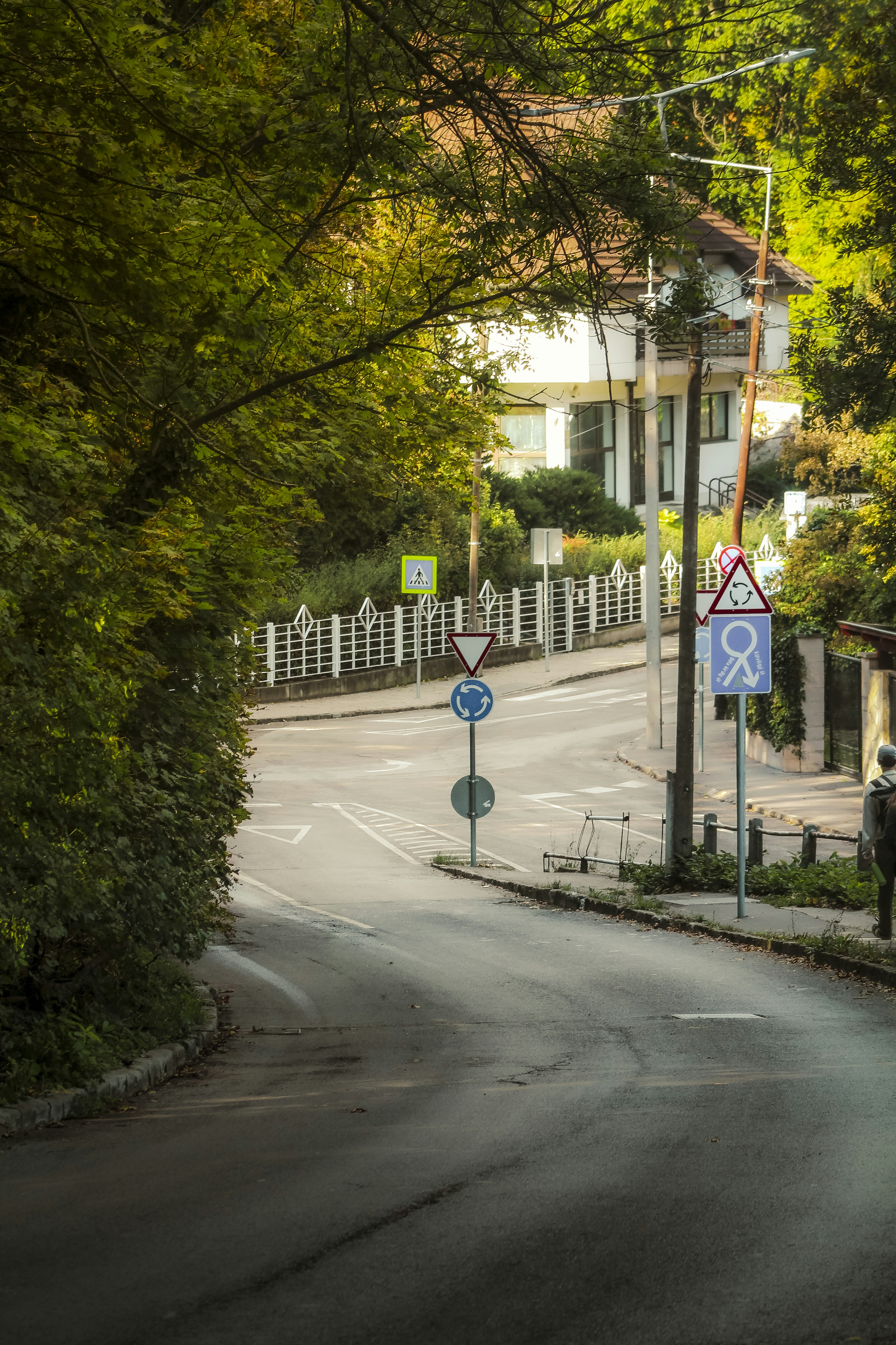 A winding road leads to a white house.