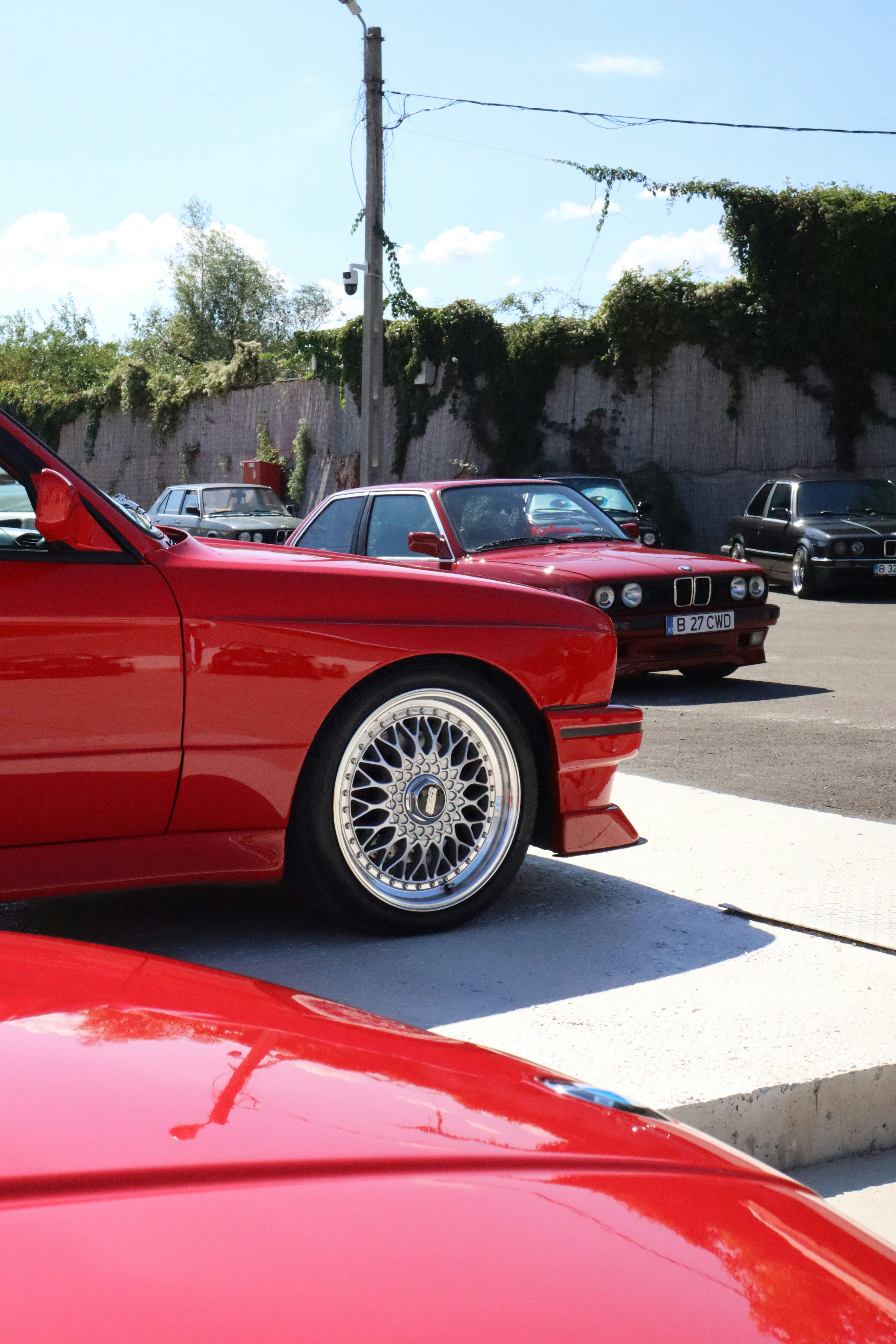 Several red BMW cars parked outdoors
