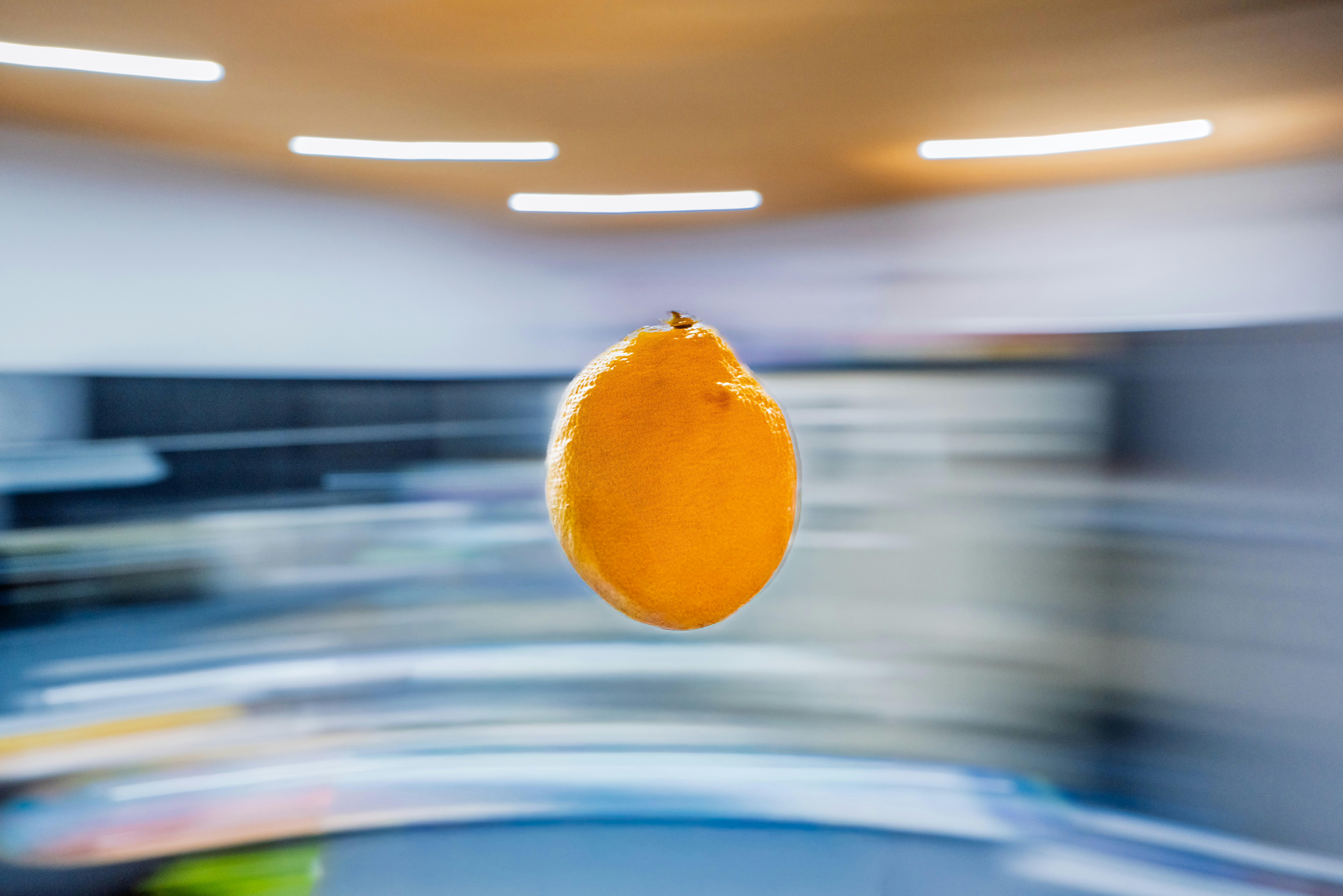 A single orange suspended in mid-air with motion blur.