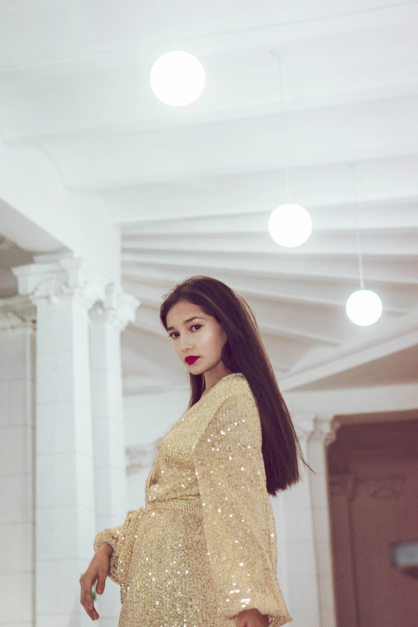 A woman in a sparkling dress, hair loose, night behind her