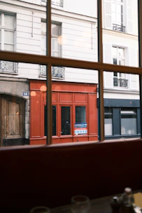 Red storefront seen through a window in paris