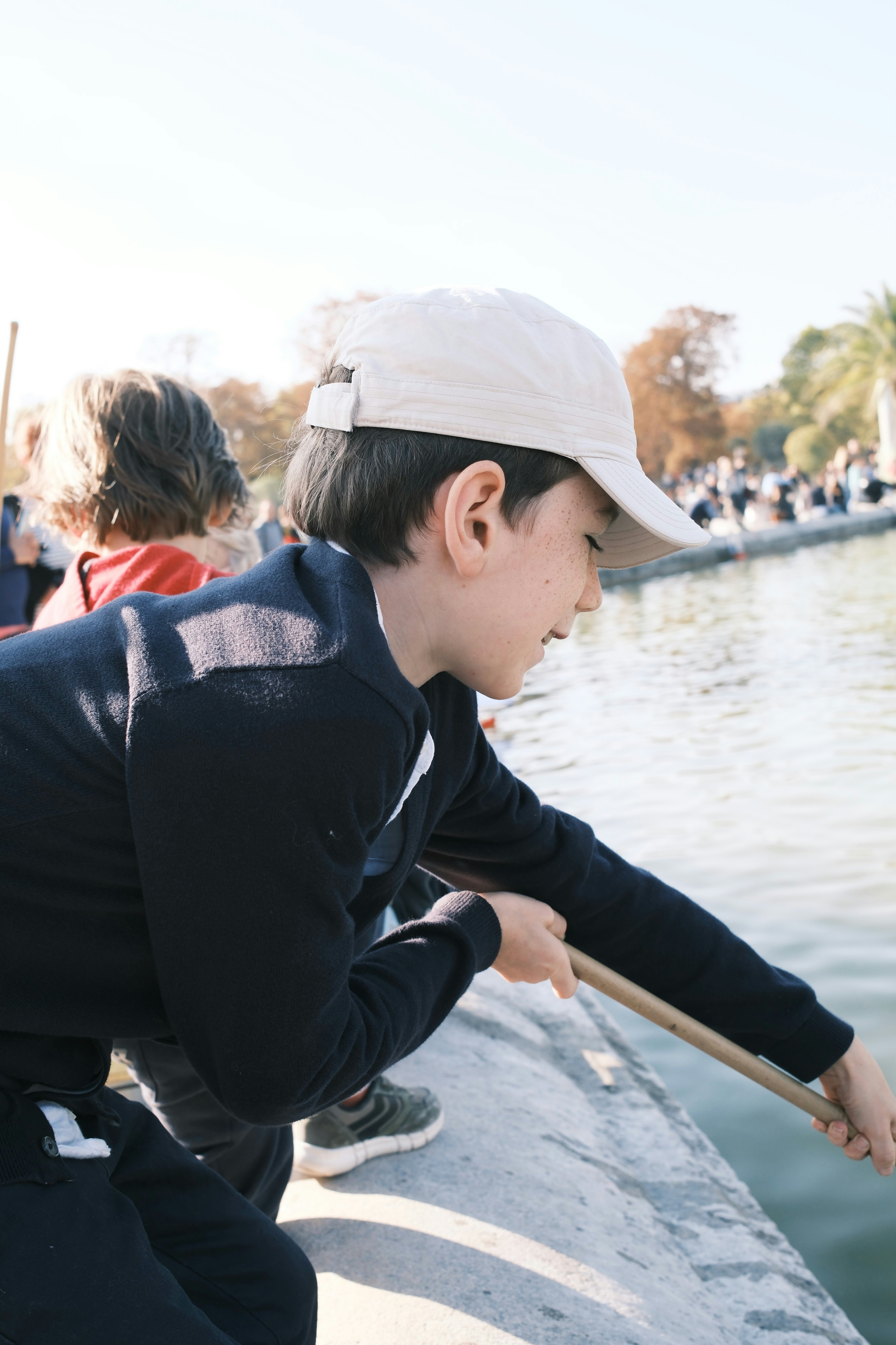 Boy with baseball cap fishing in a pond