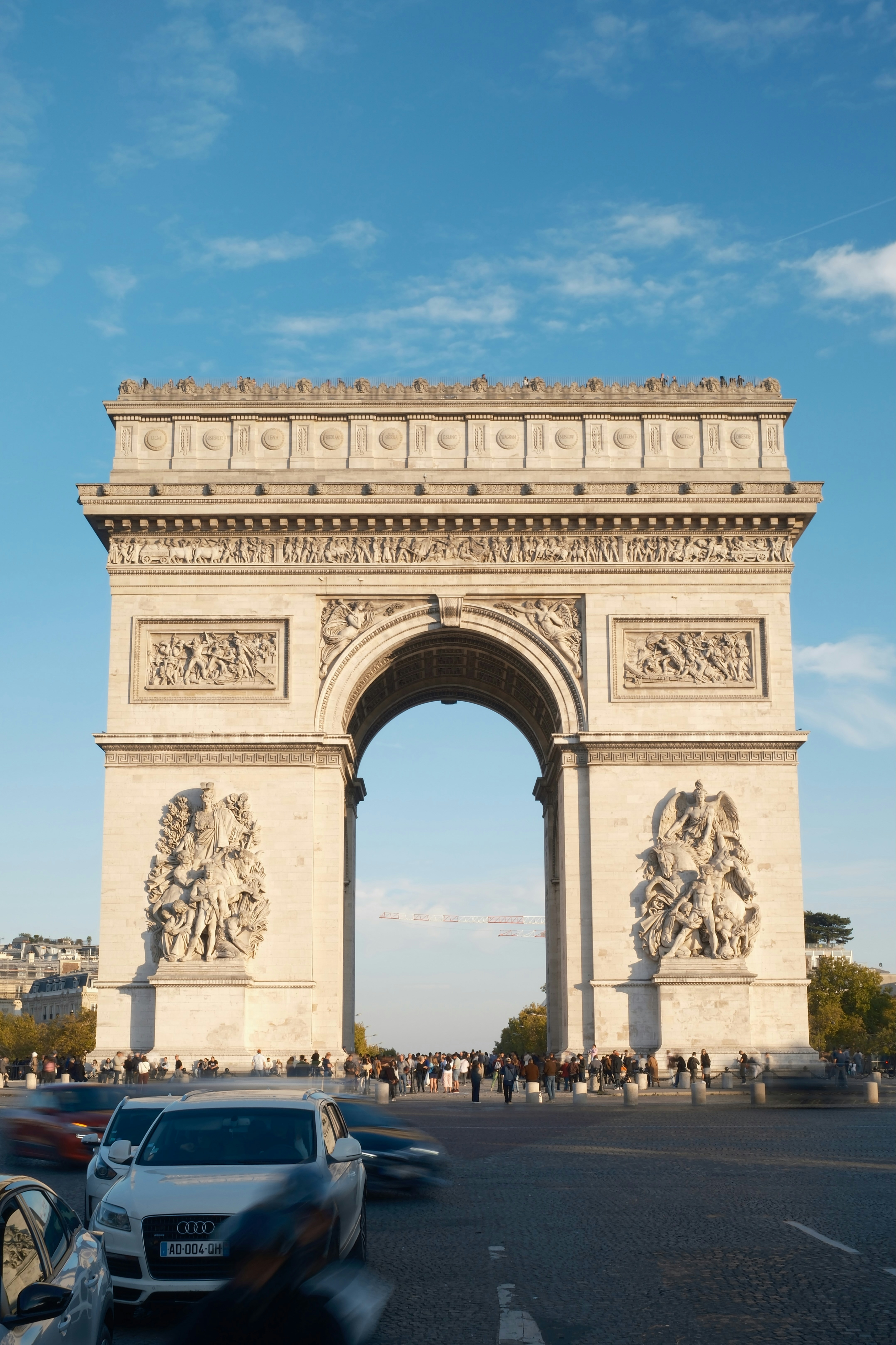The arc de triomphe in paris under a blue sky.