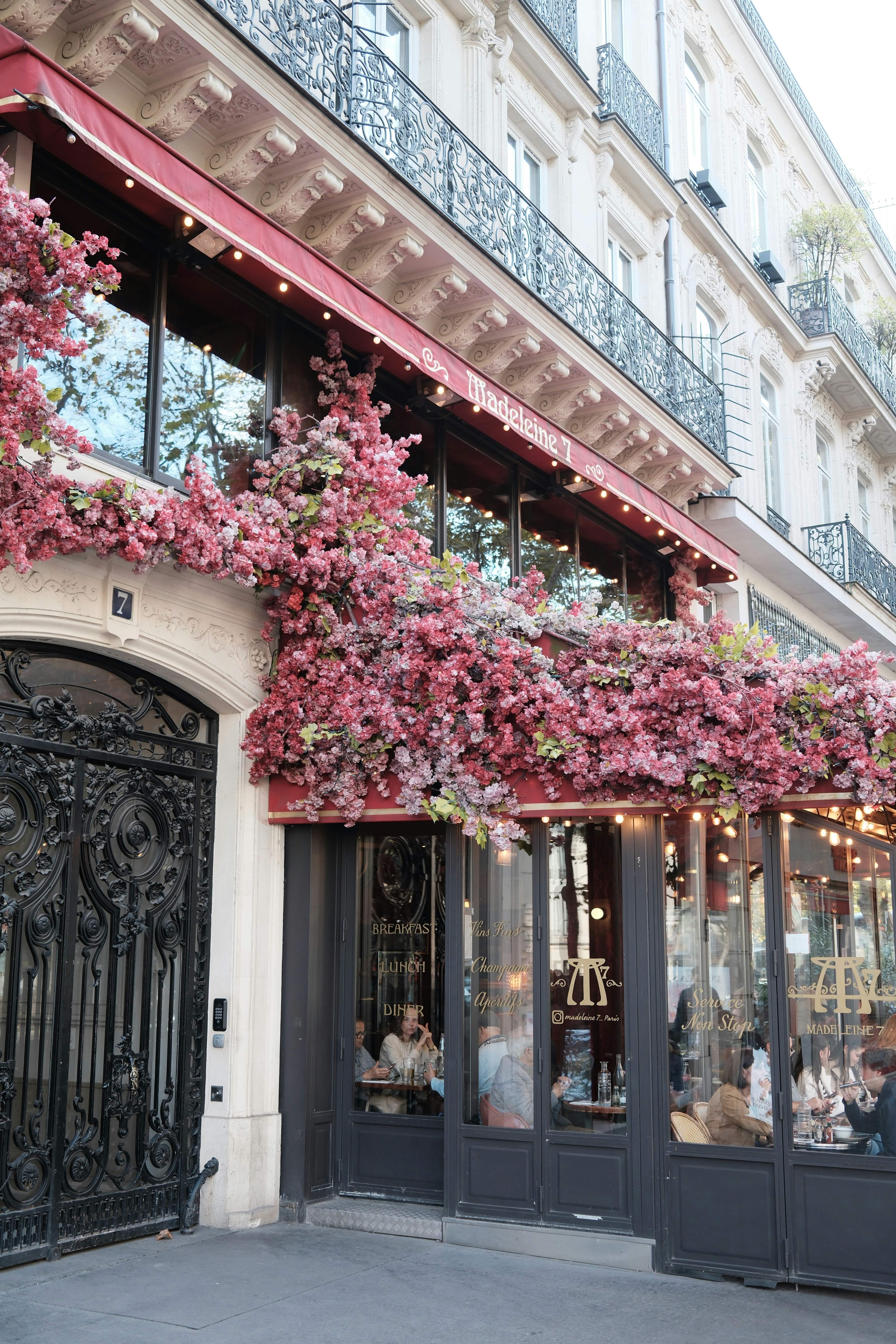 Building facade with pink flowers and outdoor seating