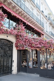 Building facade with pink flowers and outdoor seating