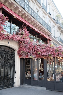 Building facade with pink flowers and outdoor seating