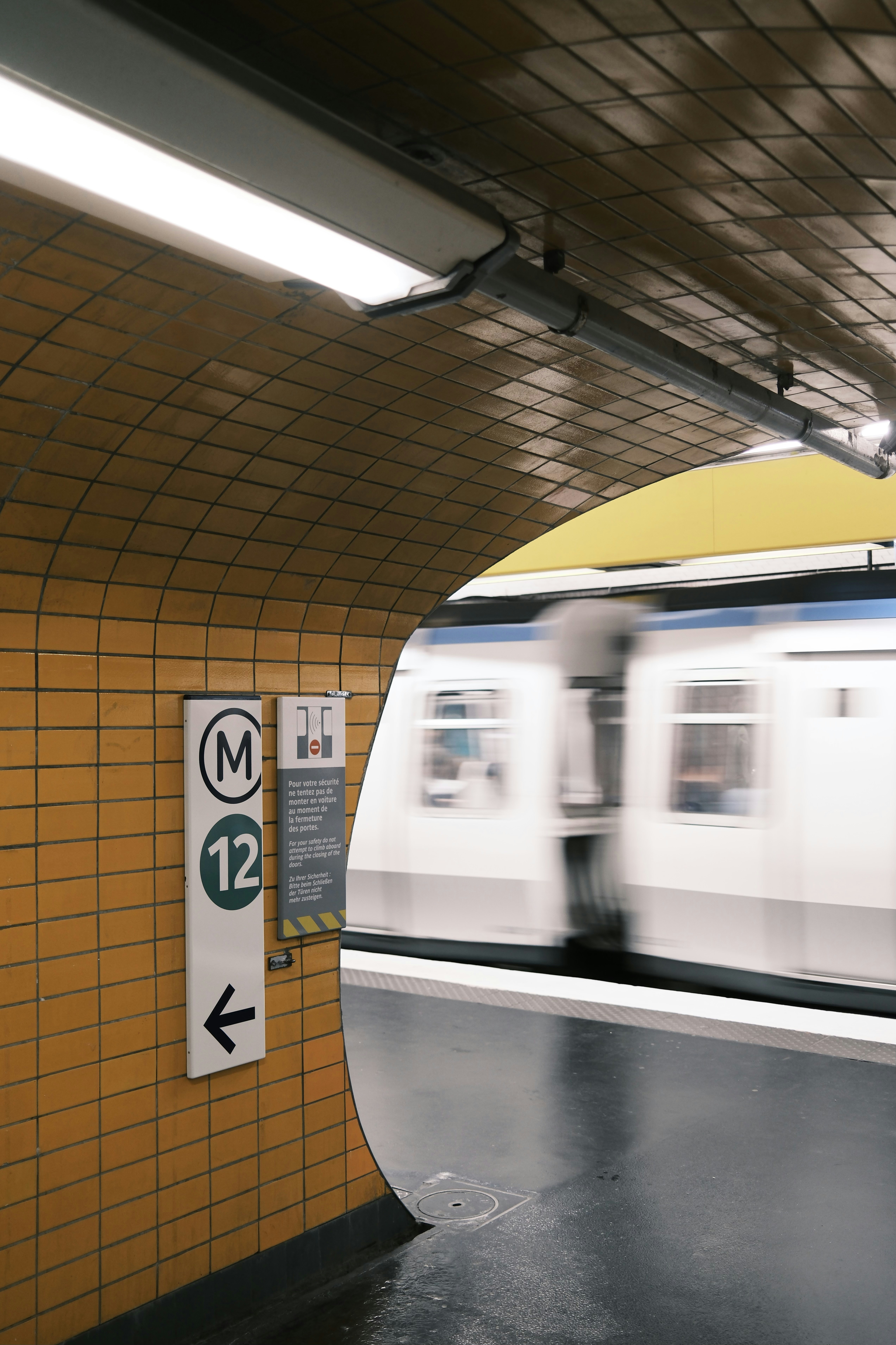 A train speeds past a subway station platform.