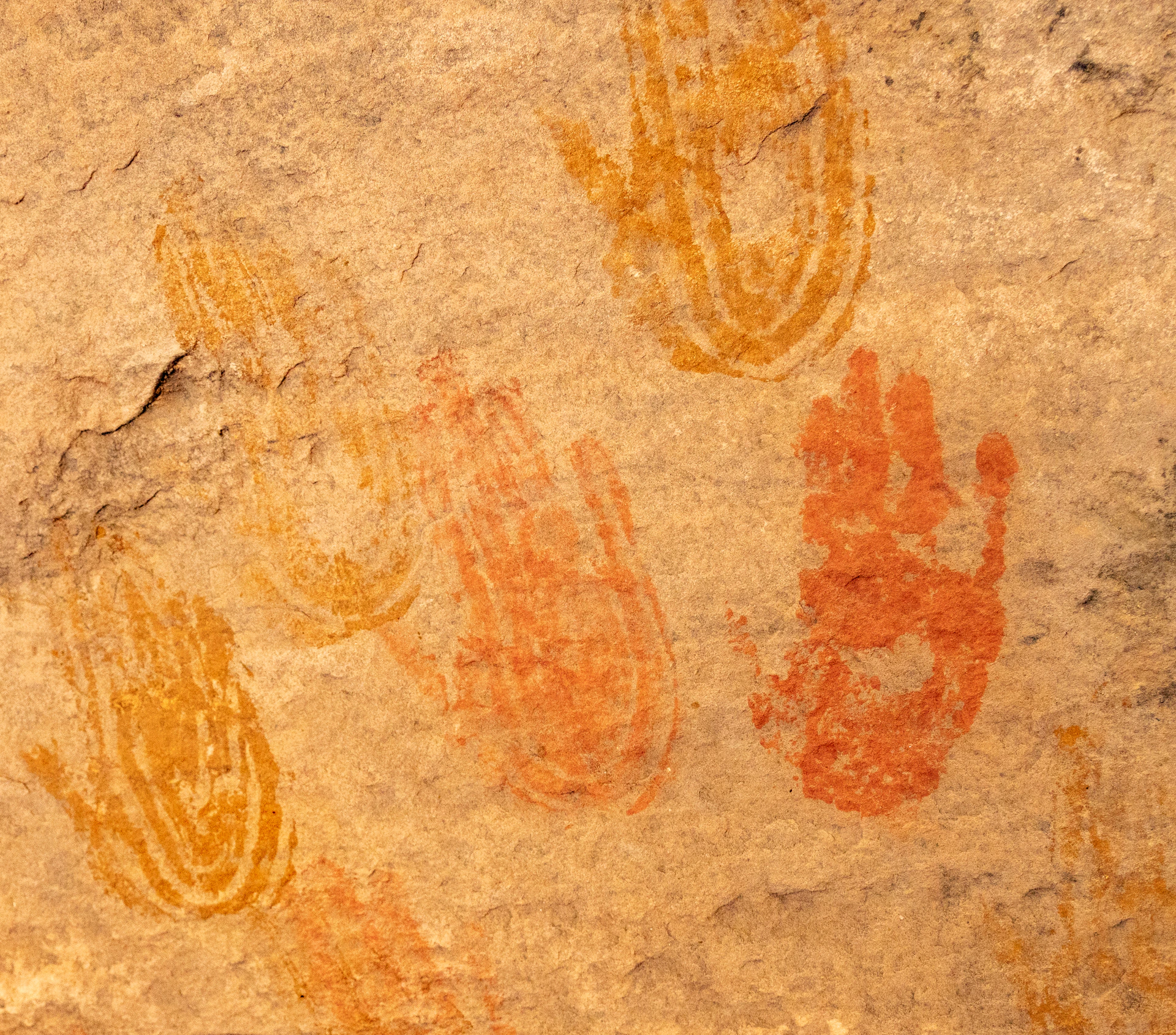 Ancient handprints painted on a rock surface.