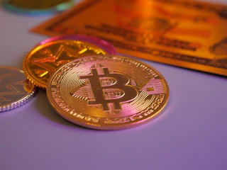 Golden bitcoin coin with other coins and card.