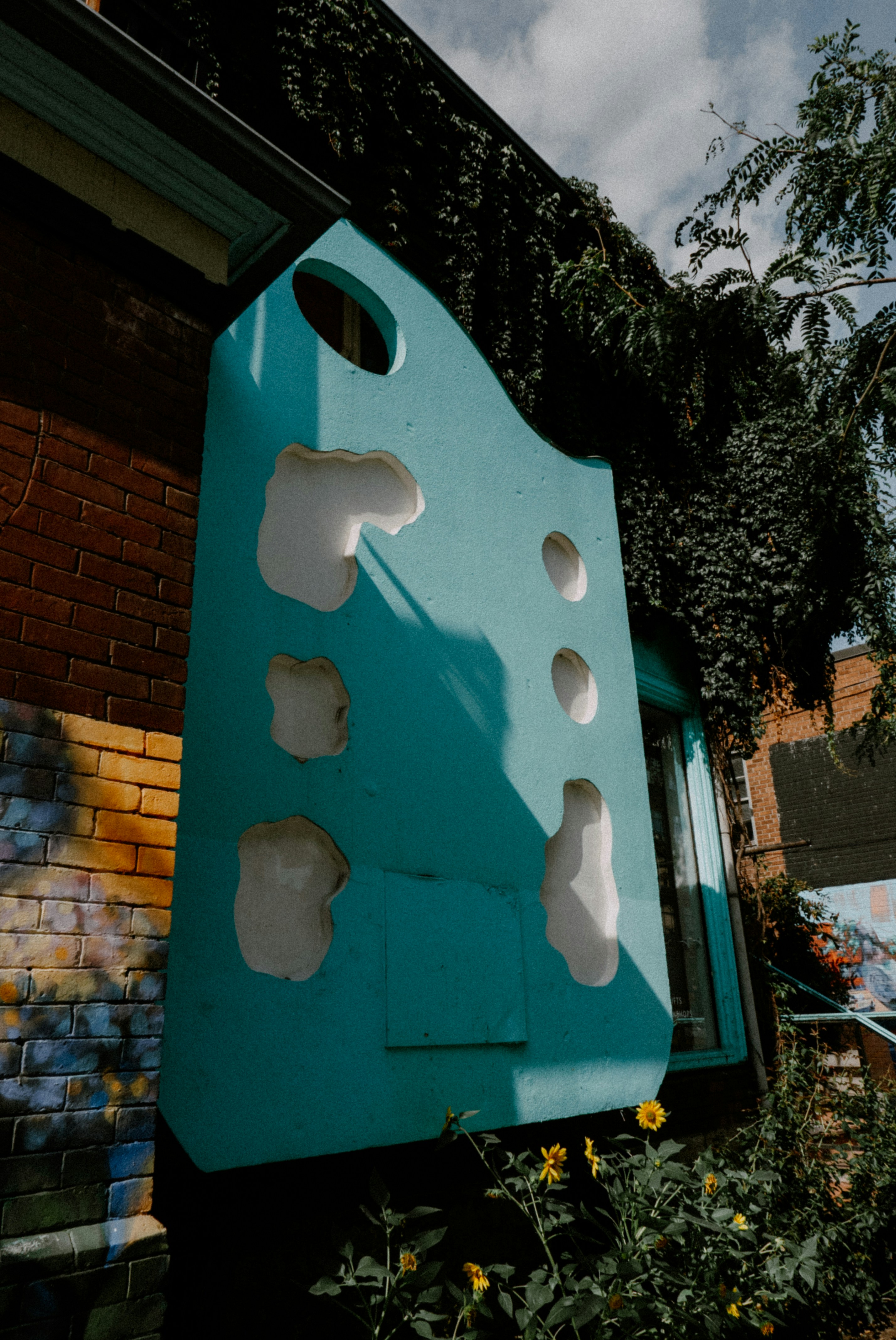 Rocódromo turquesa con agujeros en edificio de ladrillo