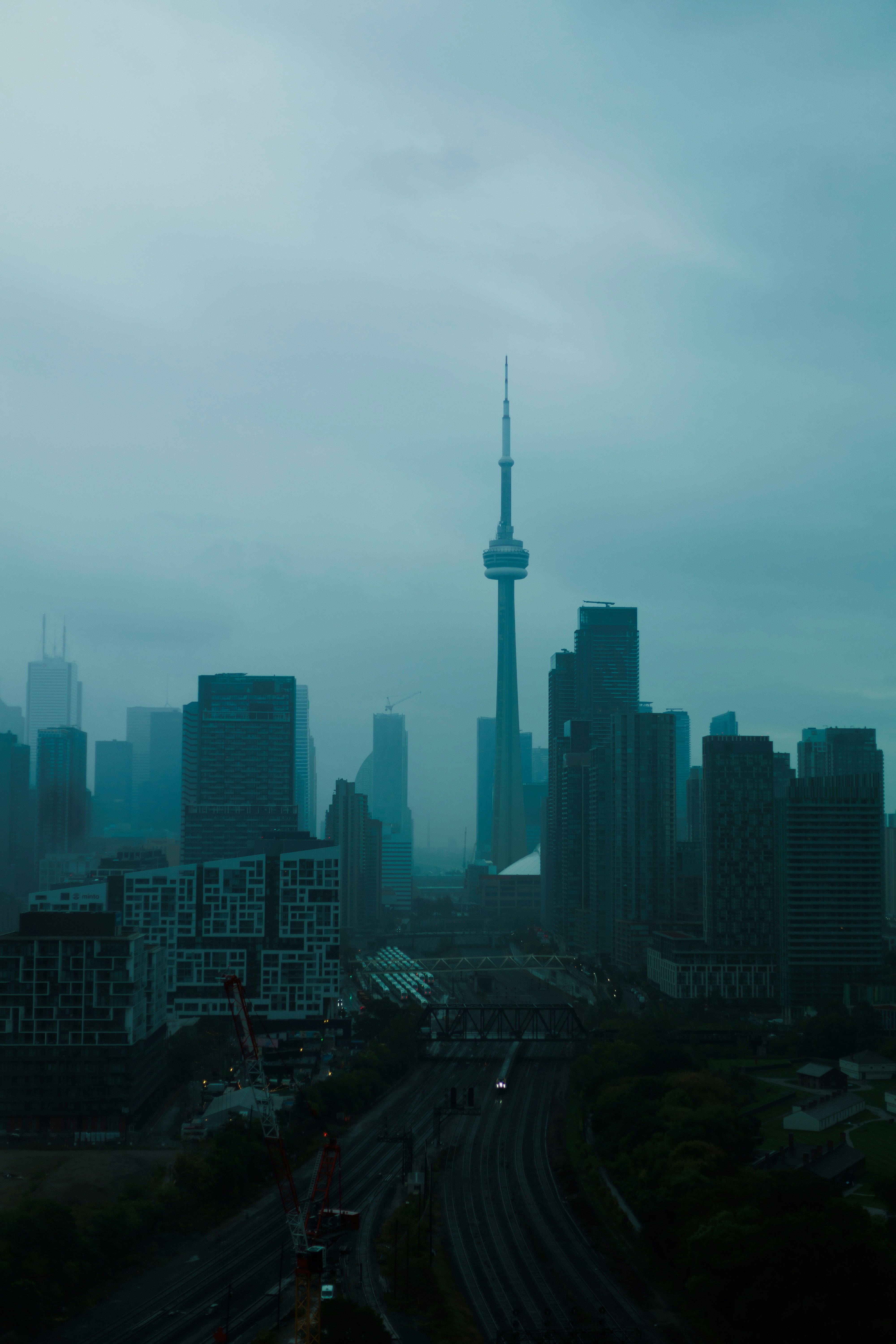 Paisaje urbano brumoso con edificios altos y torre cn.
