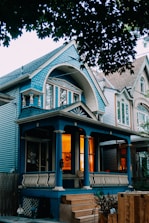 Blue house with warm lights on porch.