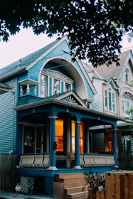 Blue house with warm lights on porch.