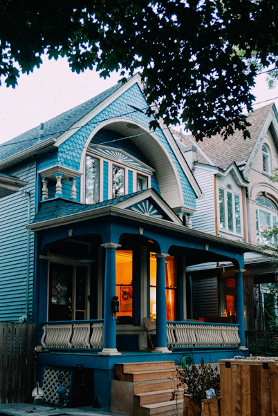 Blue house with warm lights on porch.
