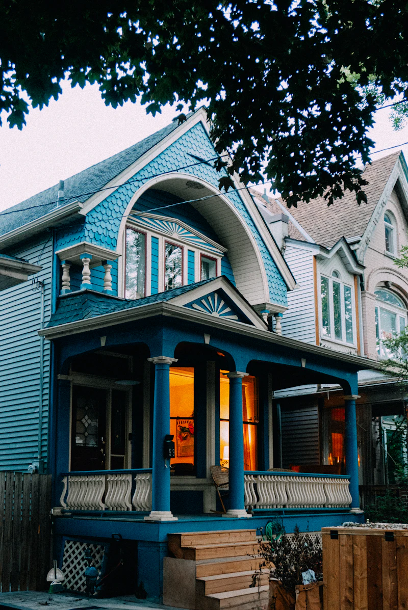 Freshly painted blue house with warm porch lights
