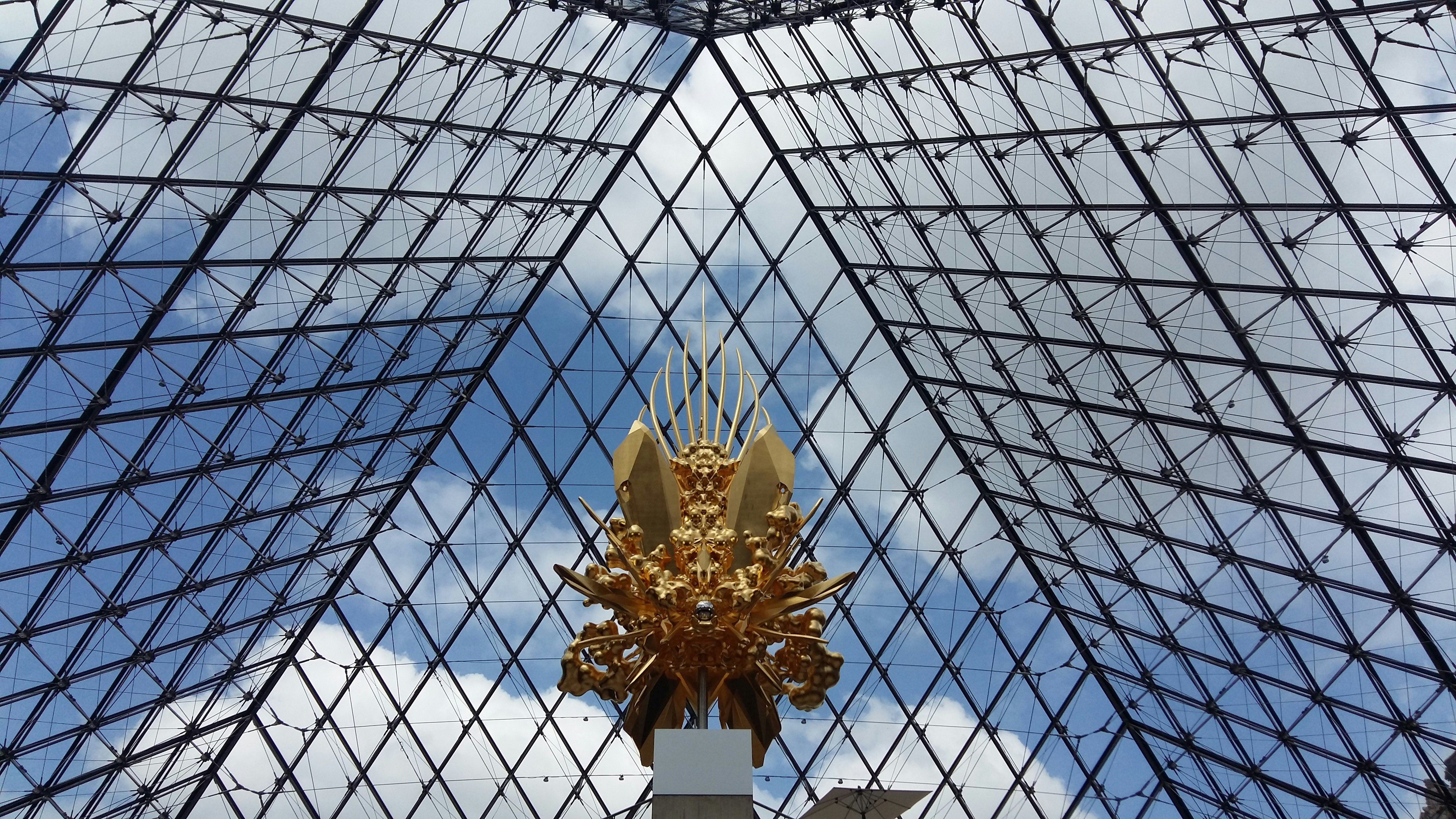 Golden statue beneath a glass pyramid ceiling