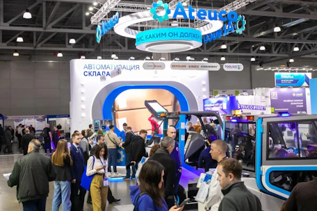 Crowd at an exhibition with booths and displays.