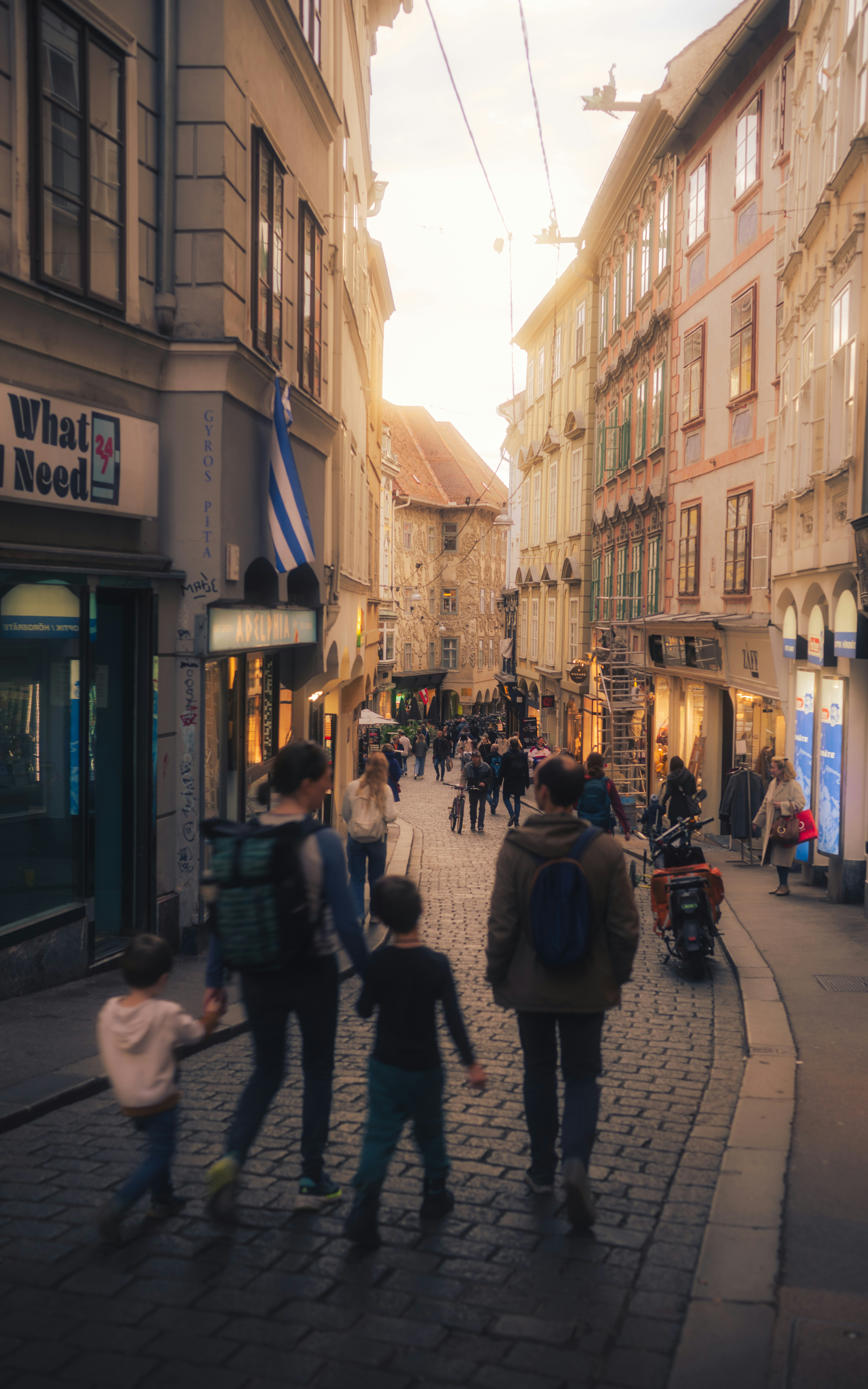 La familia camina por una calle empedrada en Europa.
