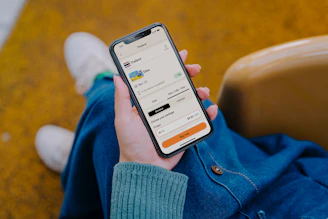 Person holding a smartphone with a ride-sharing app open