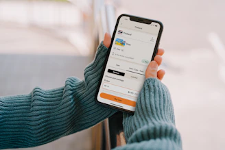Person holding a smartphone with a travel app