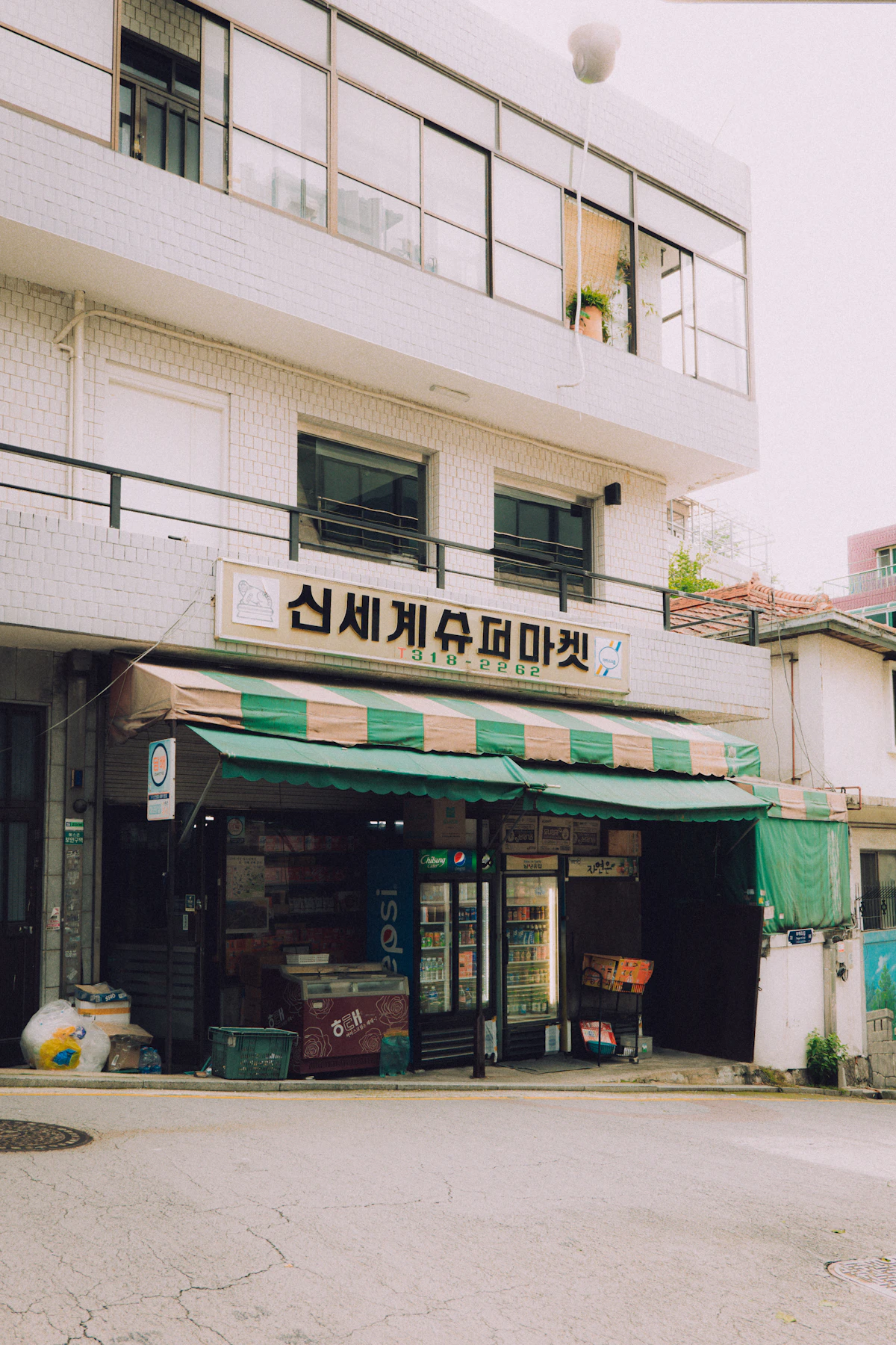 Old neighbourhood supermarket in Seoul with a green striped awning