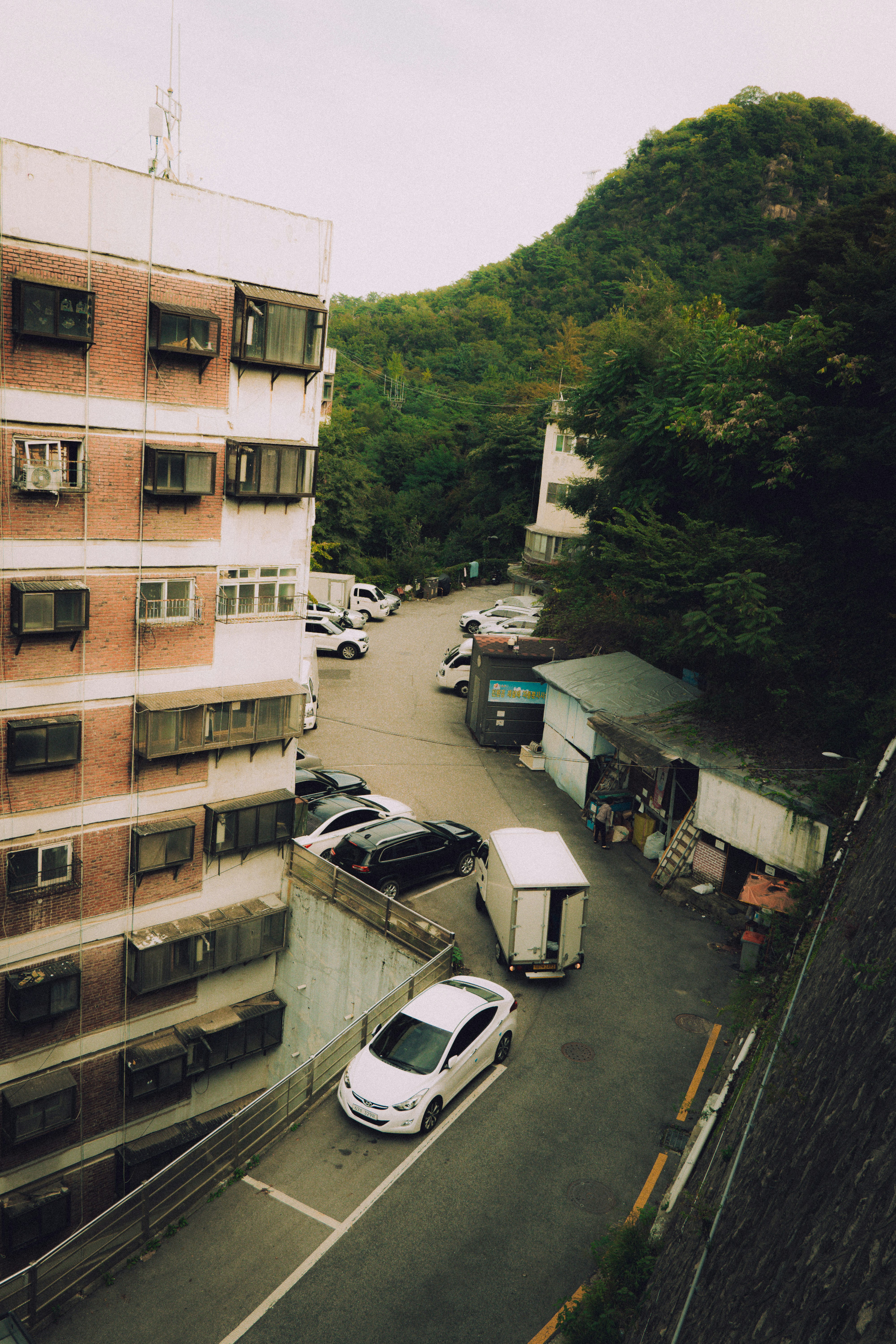 Apartment buildings and parked cars on a street.