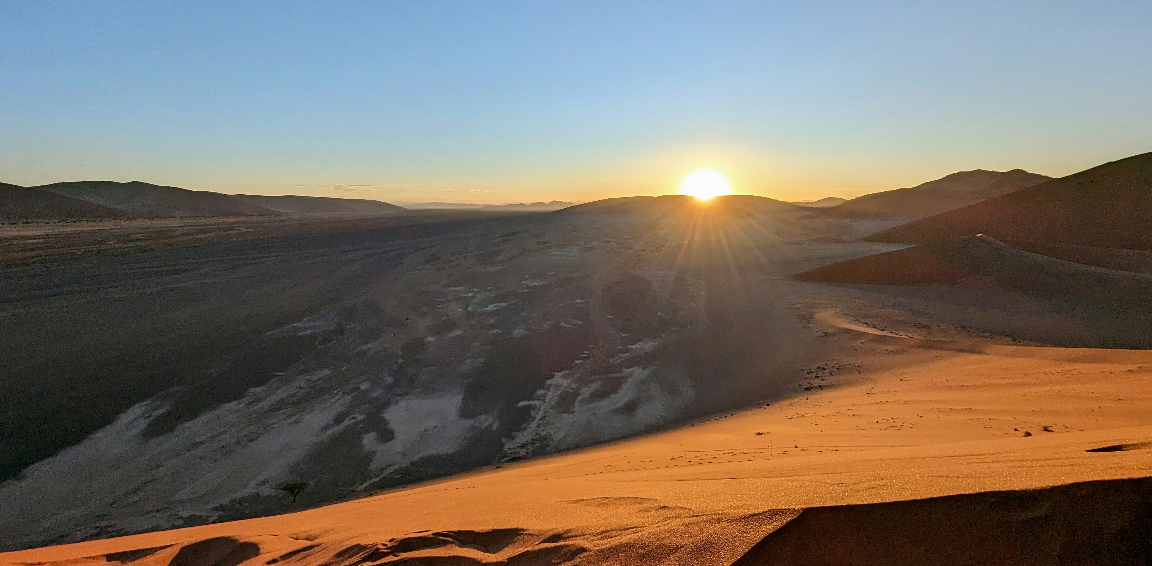 Lever de soleil sur le vaste désert, les dunes de sable et les montagnes.