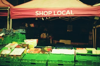 Market stall with 'shop local' banner and fresh produce