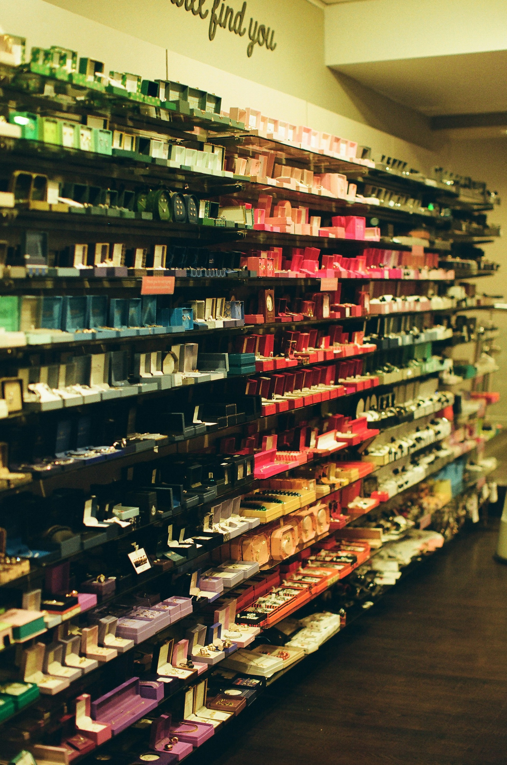 Shelves of colorful boxes arranged by color gradient.