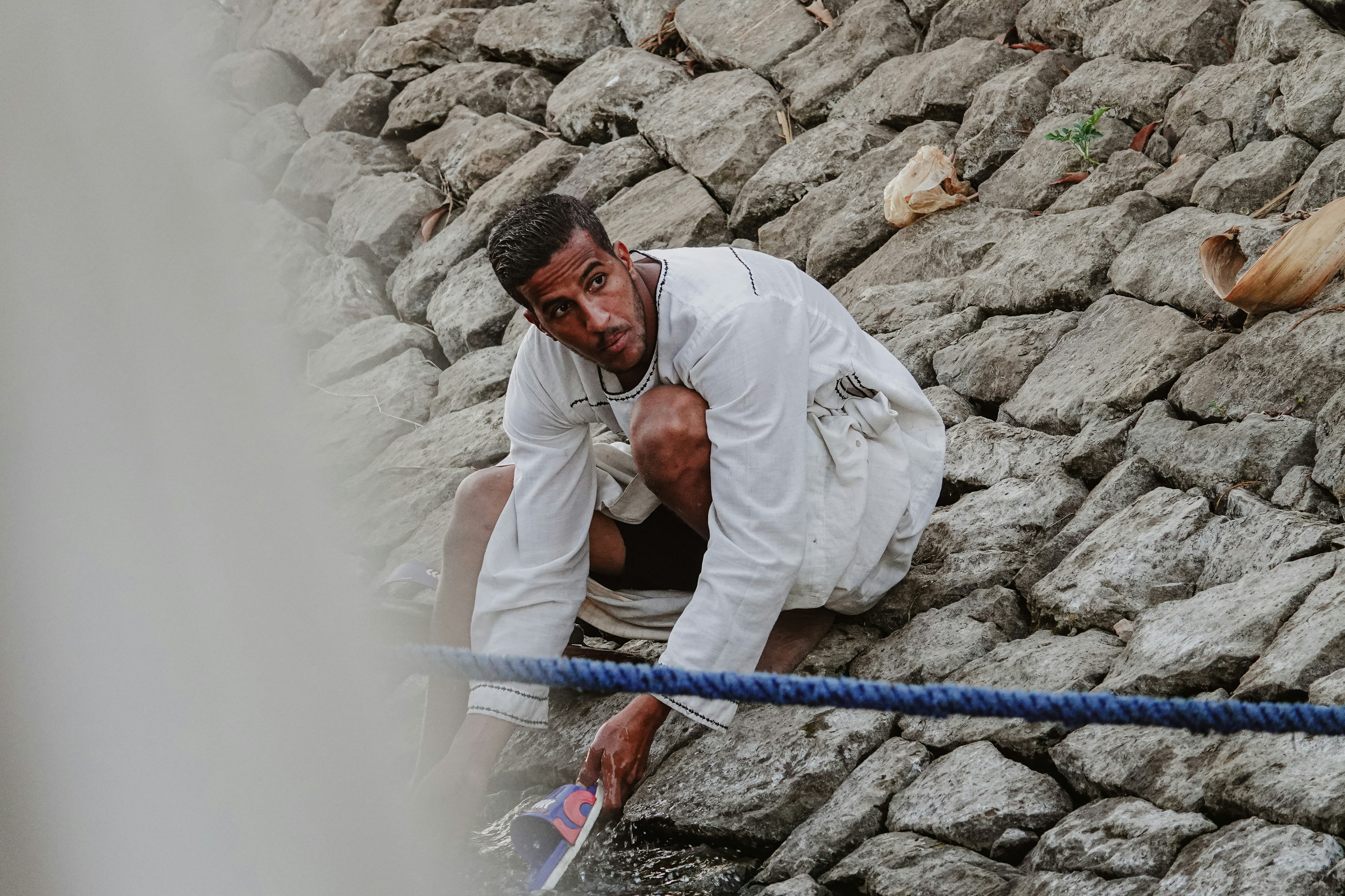Homme escaladant une paroi rocheuse avec une corde