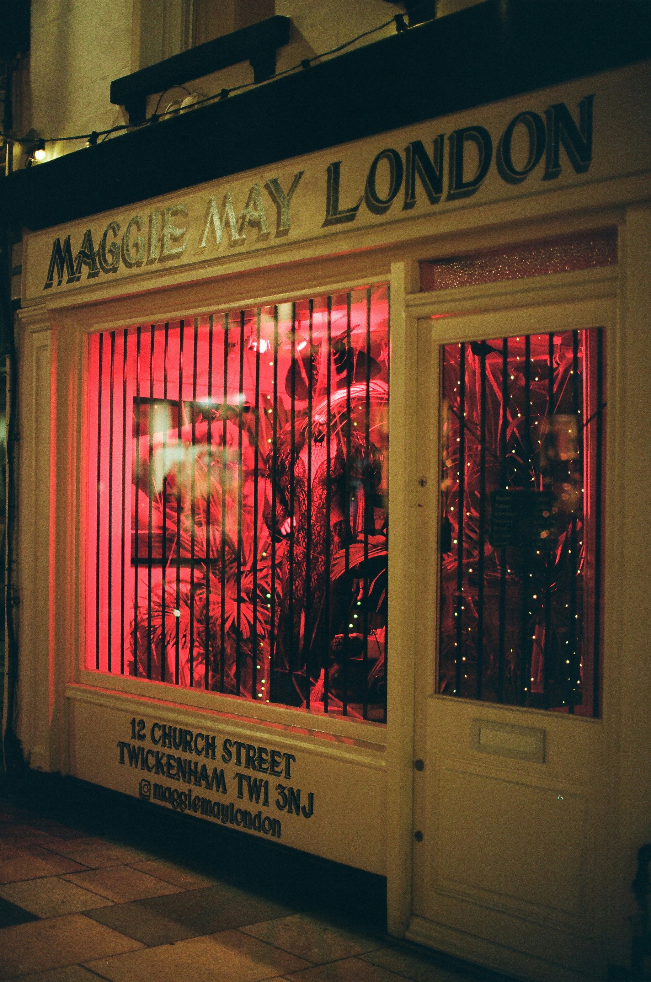 Maggie may london storefront with red lighting