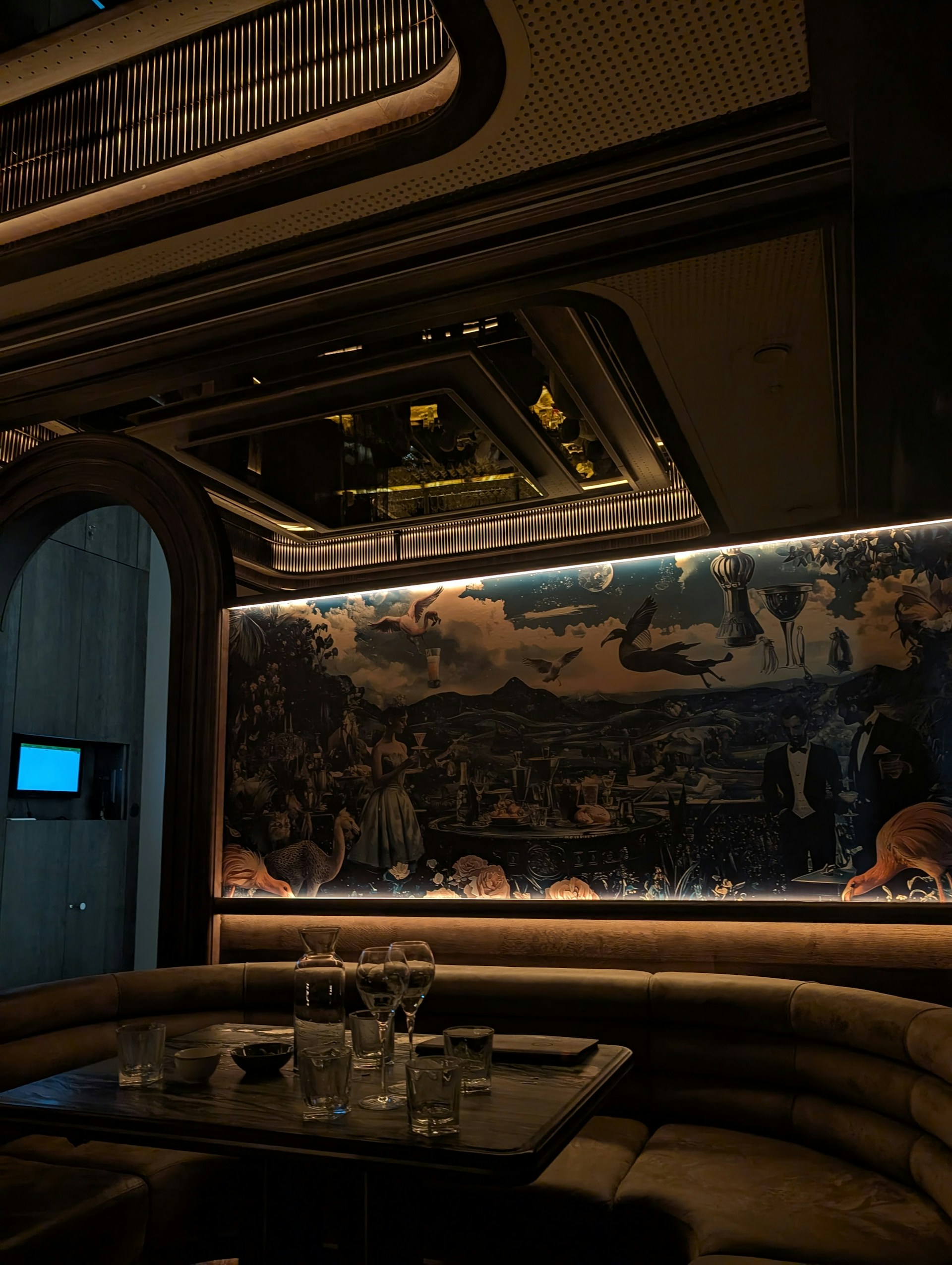 Luxurious booth seating with mural in dimly lit lounge.
