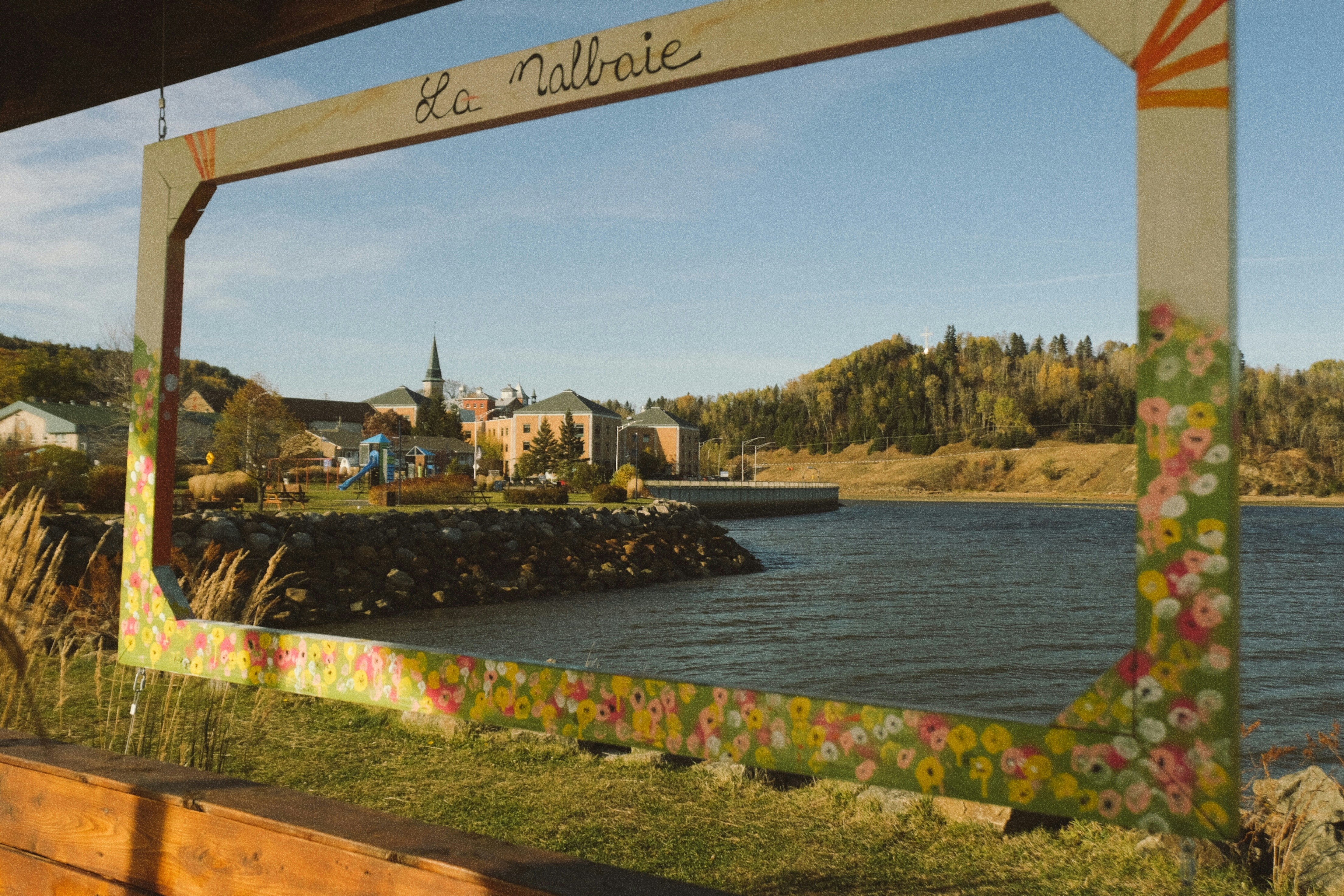 Vue encadrée d’une ville côtière avec un clocher d’église.