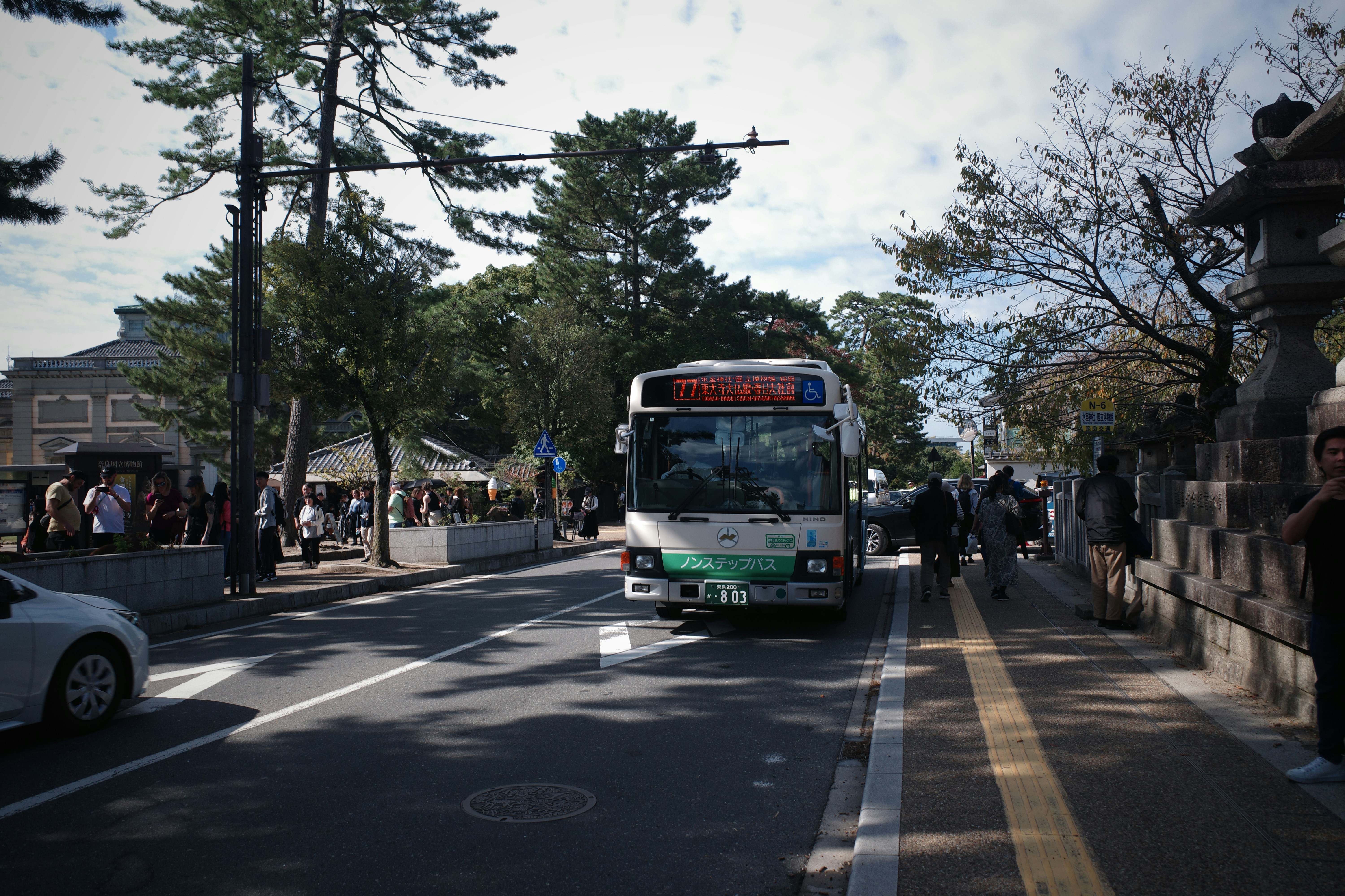 A bus drives down a street with trees.