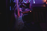 Electric guitar and amplifier in dim purple lighting.