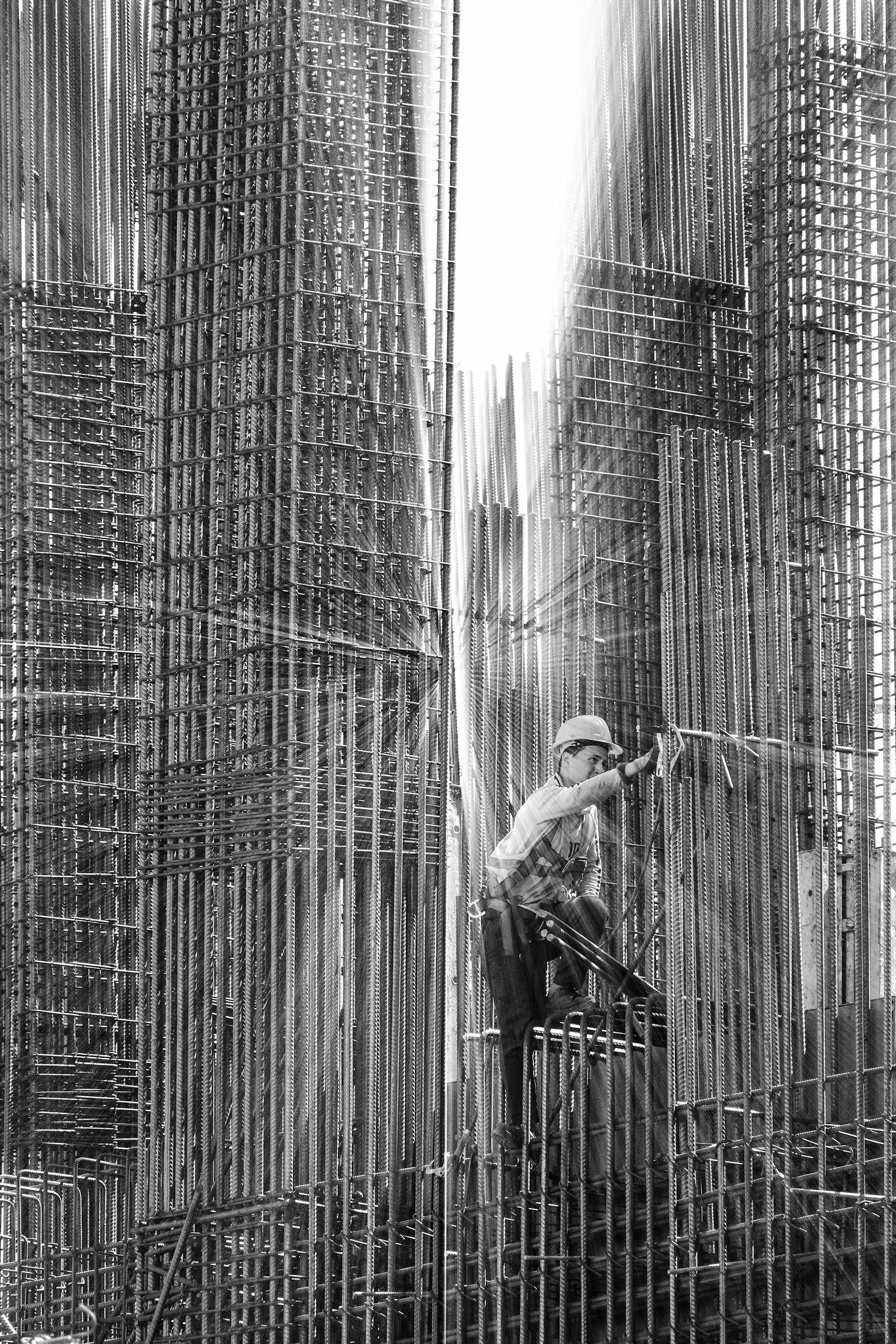 A steelfixer tying reinforcing bar inside a wall cage