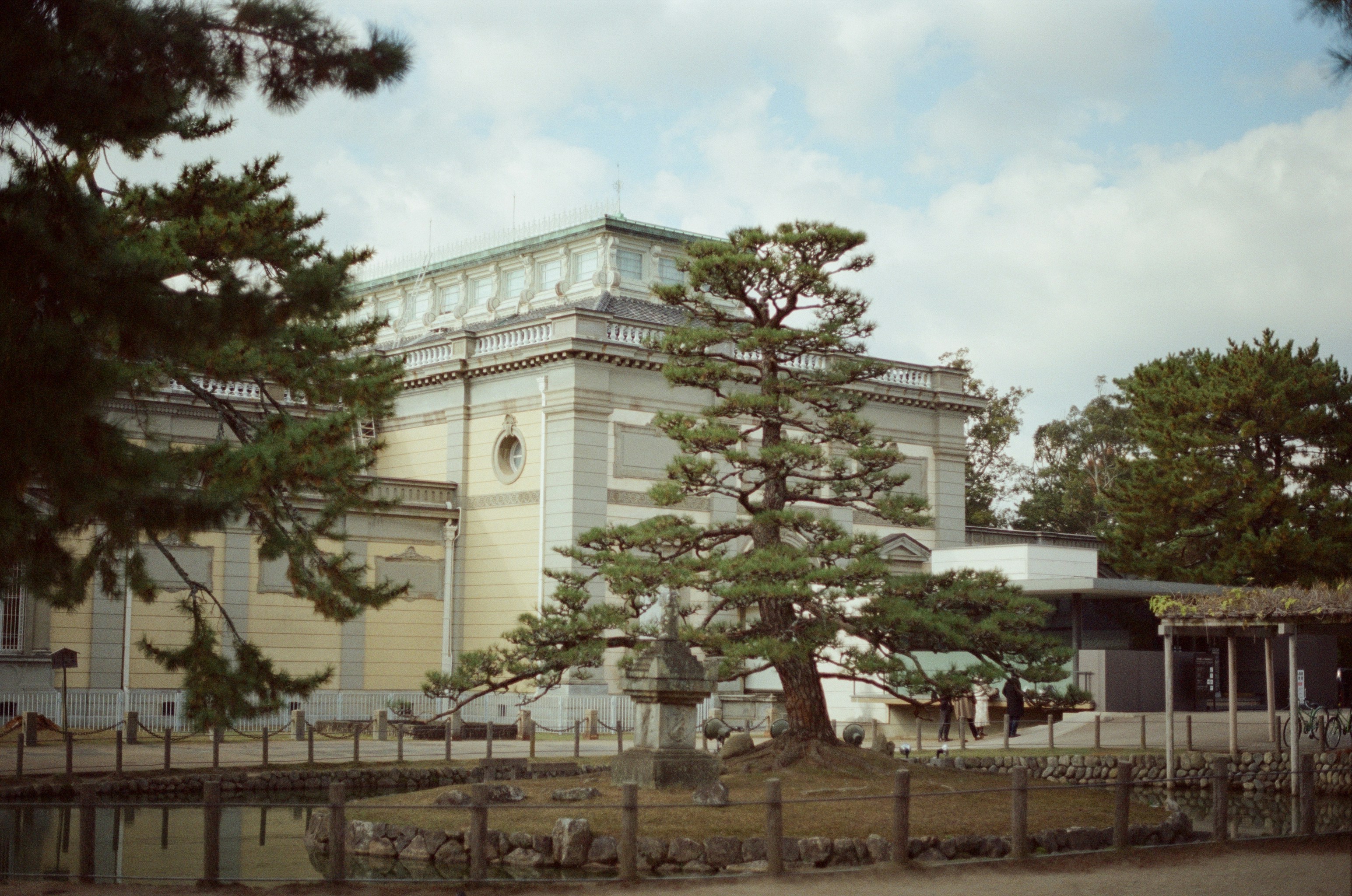 Building with trees and pond in foreground