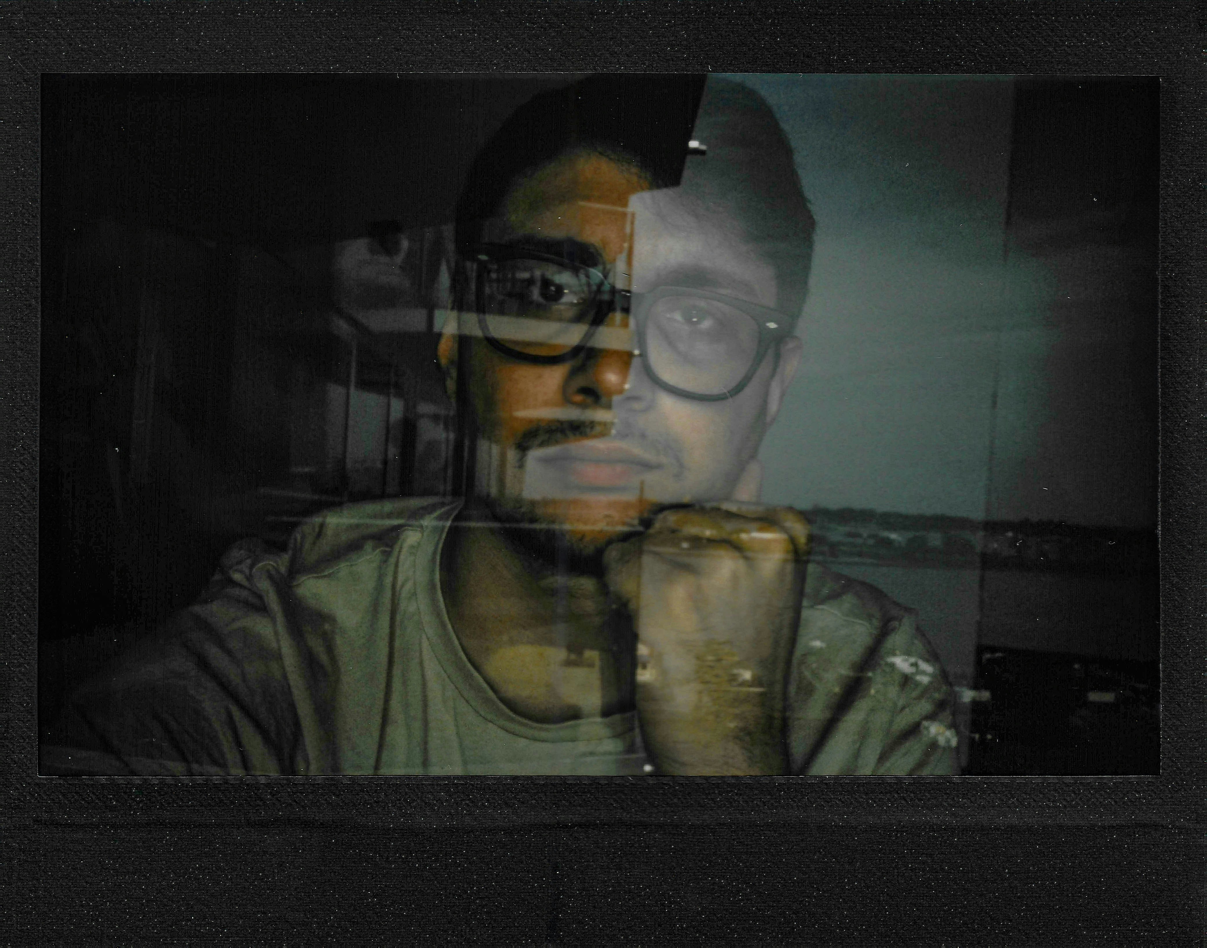 Man with glasses looking through a window