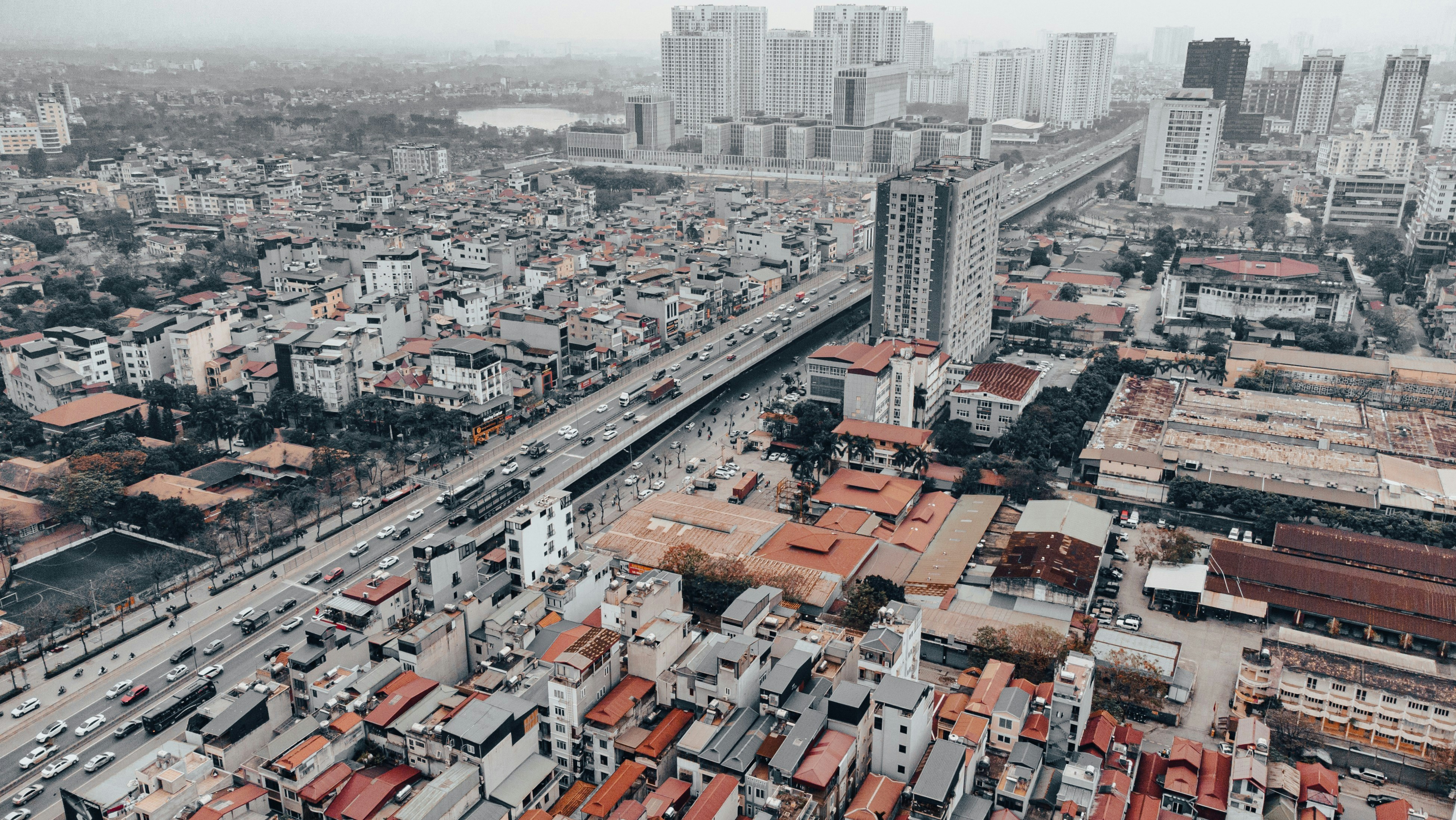 Aerial view of a dense cityscape with traffic on highway.