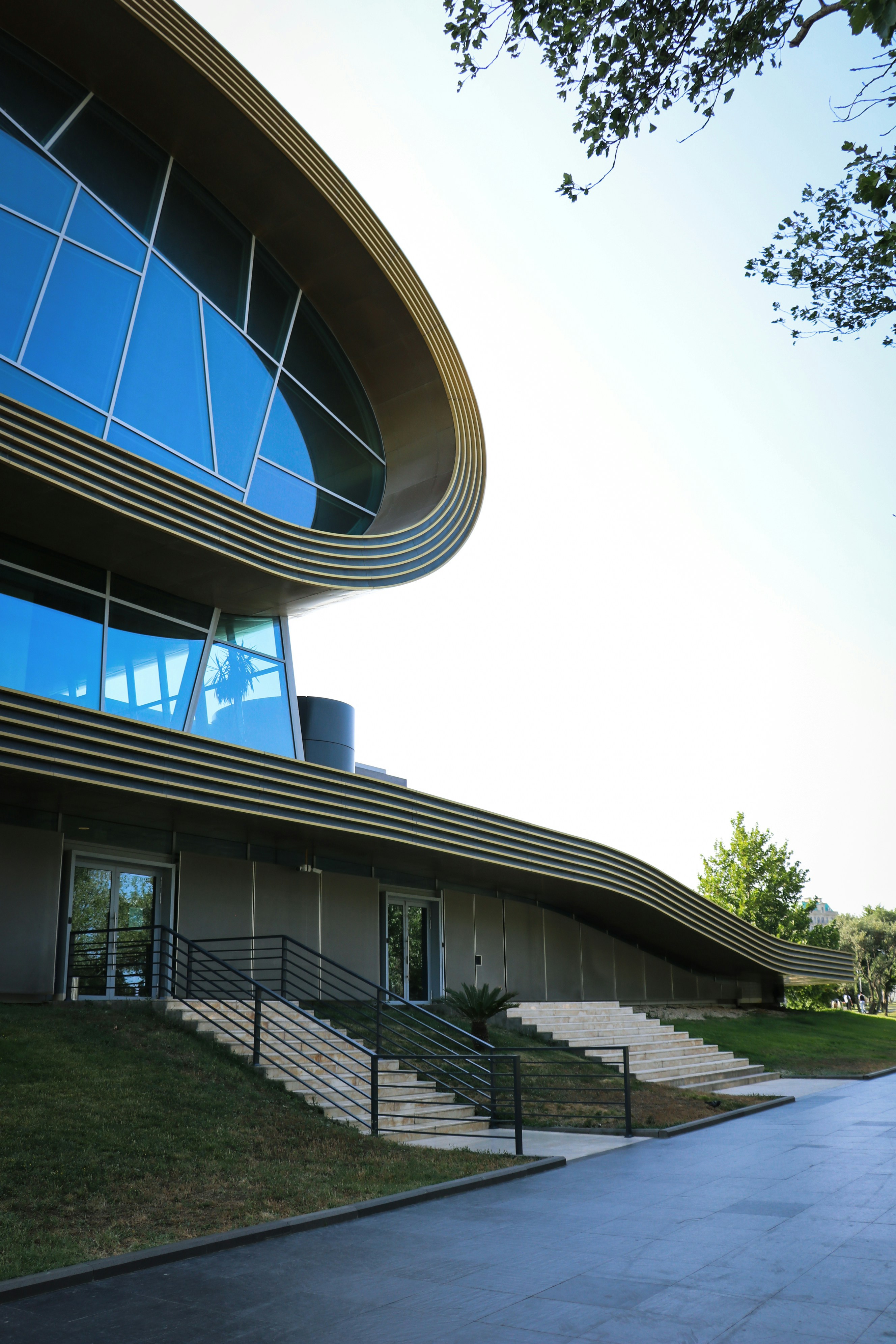 Modern building with curved glass windows and metallic accents.