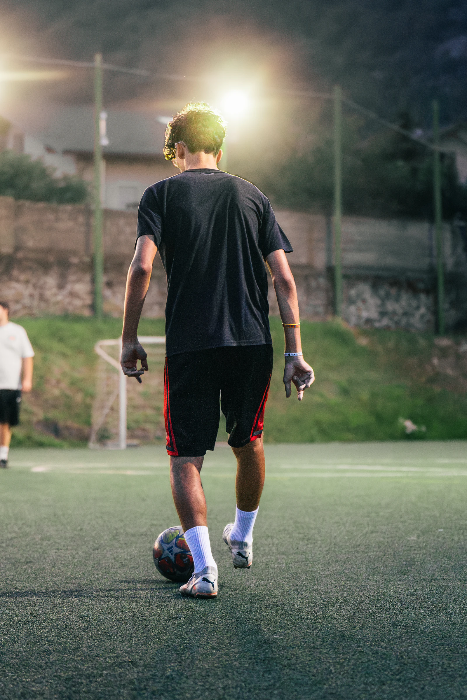 Young athlete training on a field under night lights