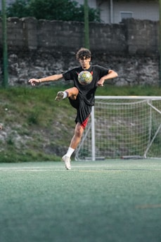 Teenager practicing soccer tricks on a field