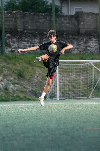 Teenager practicing soccer tricks on a field