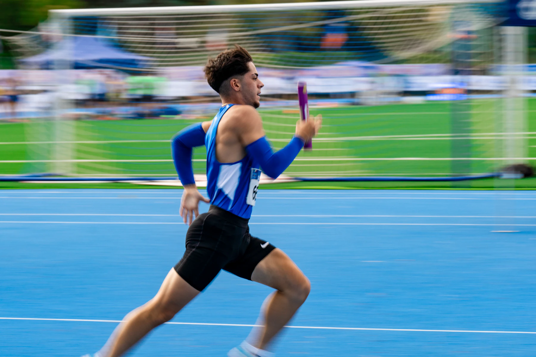 Athlete competing in a relay race with a baton