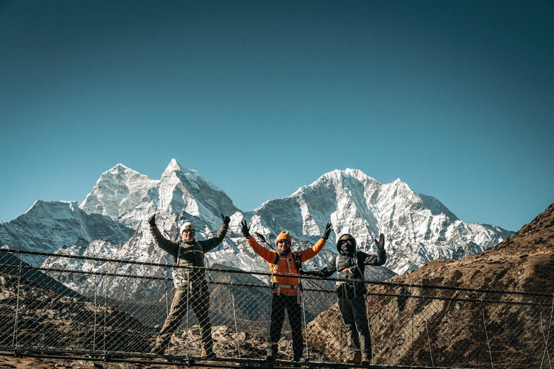 Corporate team celebrating on Himalayan suspension bridge Nepal leadership retreat