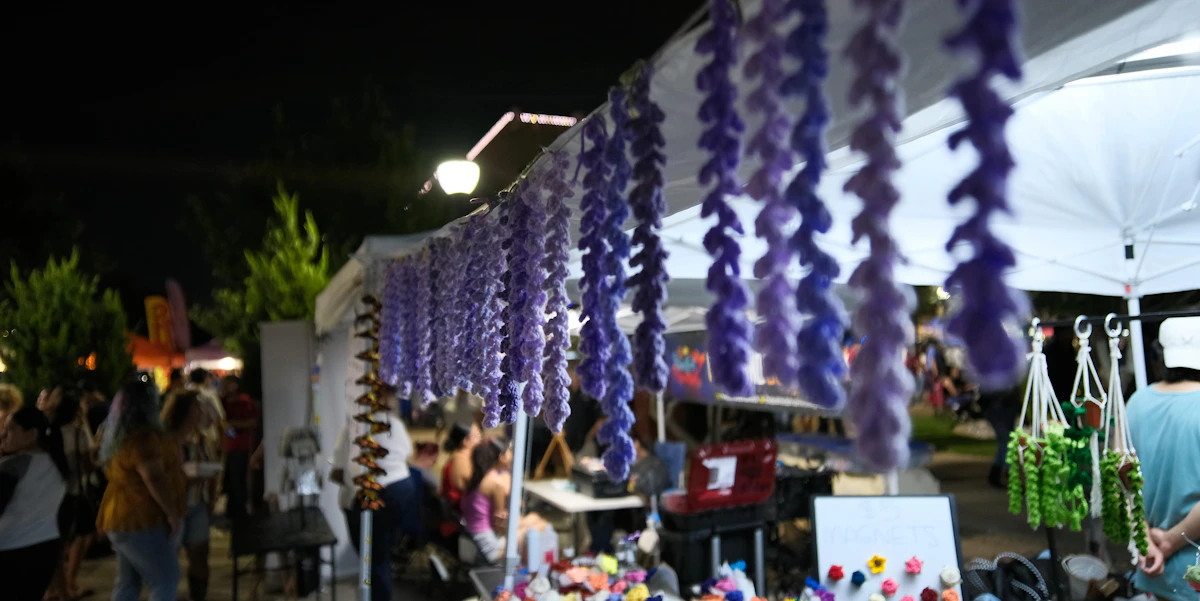 Purple decorations hang at a nighttime market stall