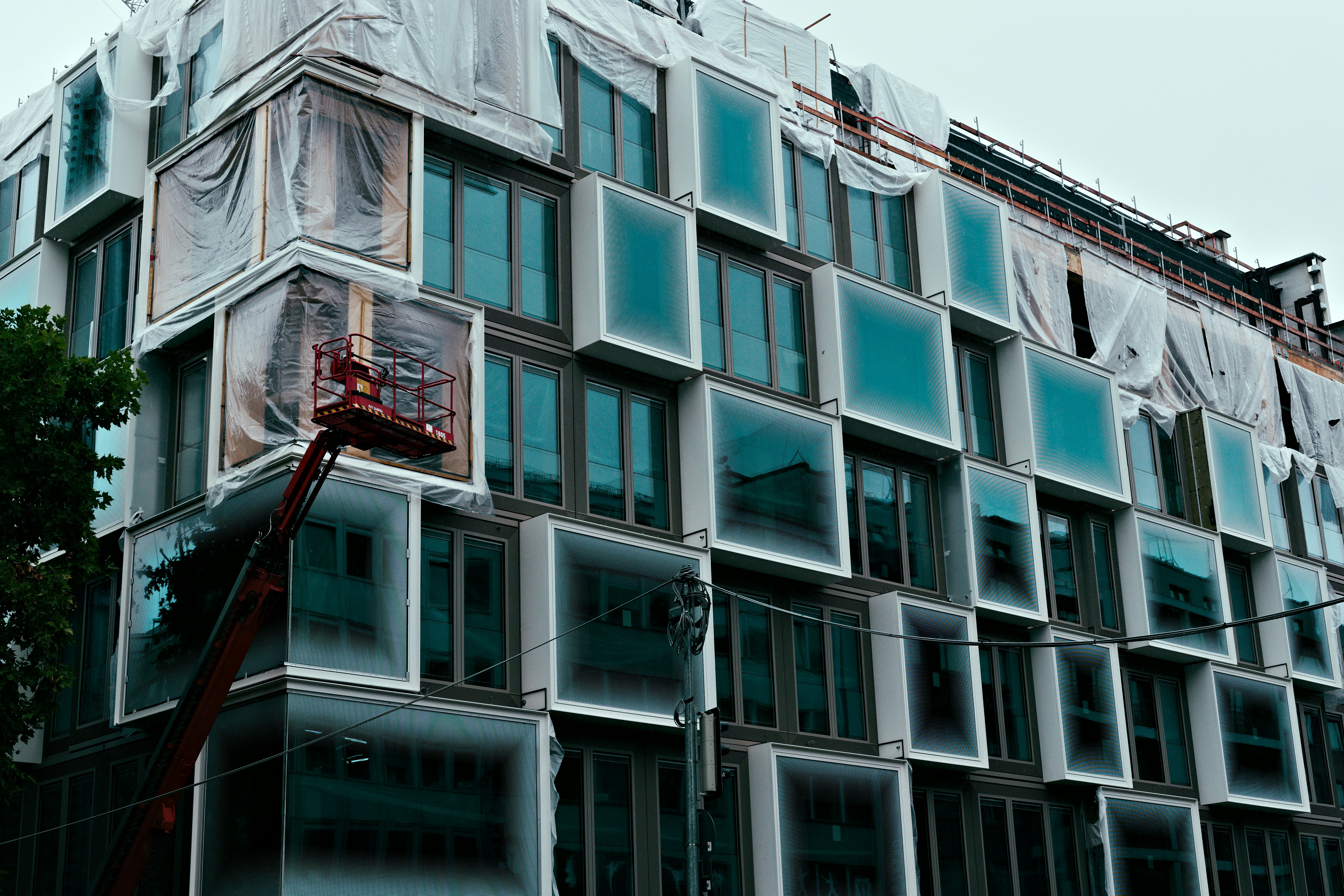 Modern building under construction with unique window design.