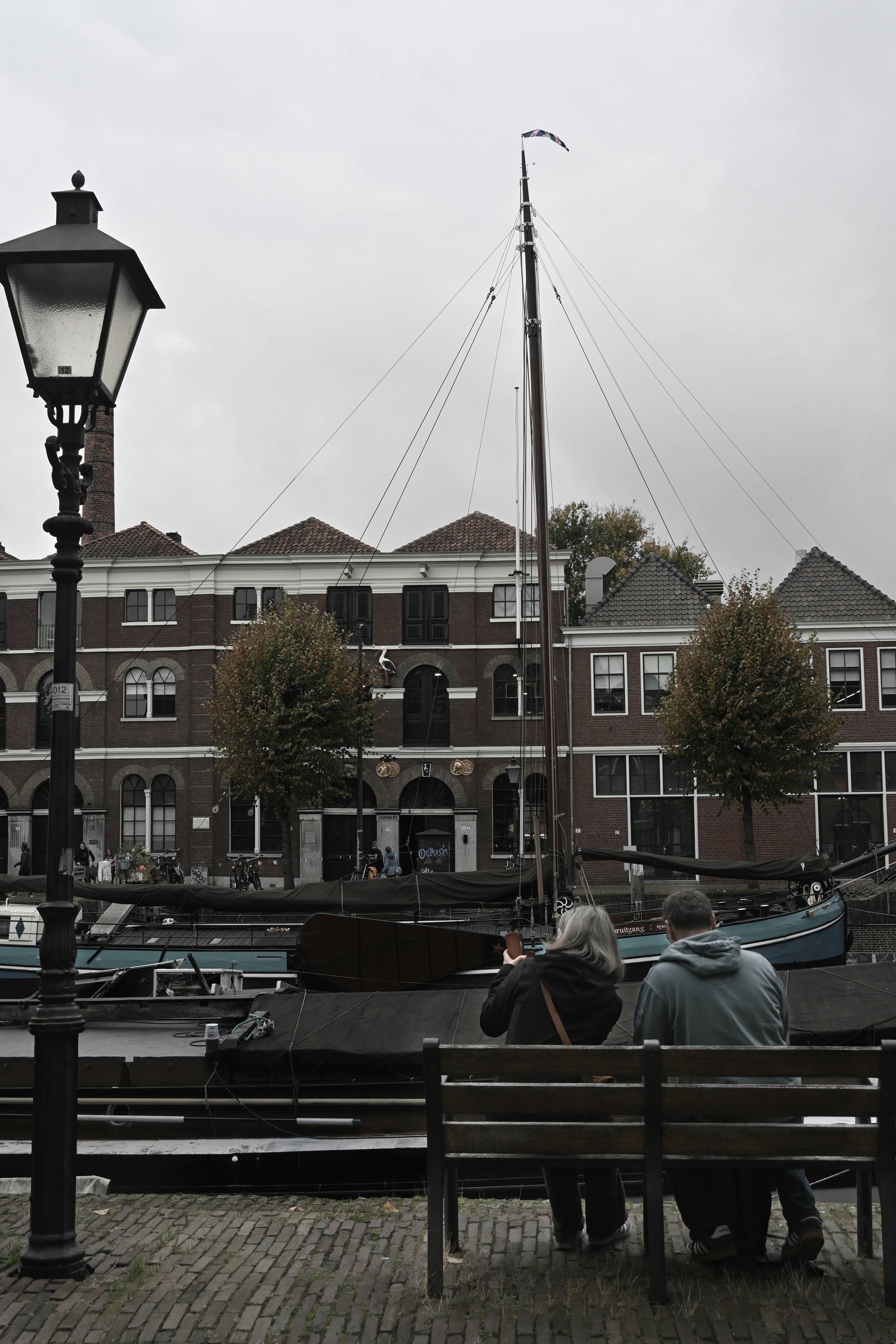Couple sitting on bench overlooking canal boats