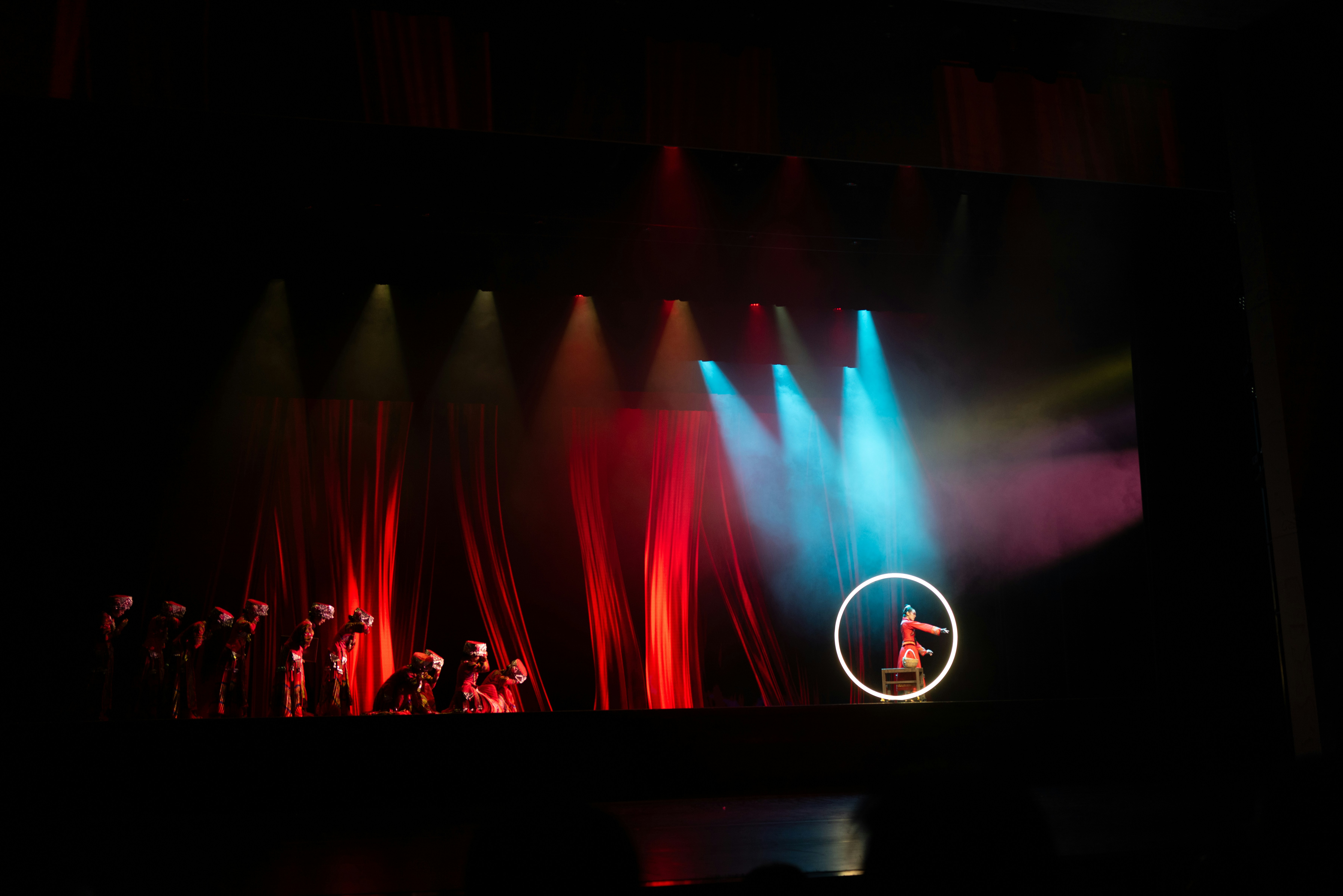 Performers on stage with red and blue lights