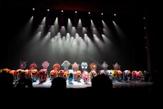 Performers bow on a brightly lit stage.